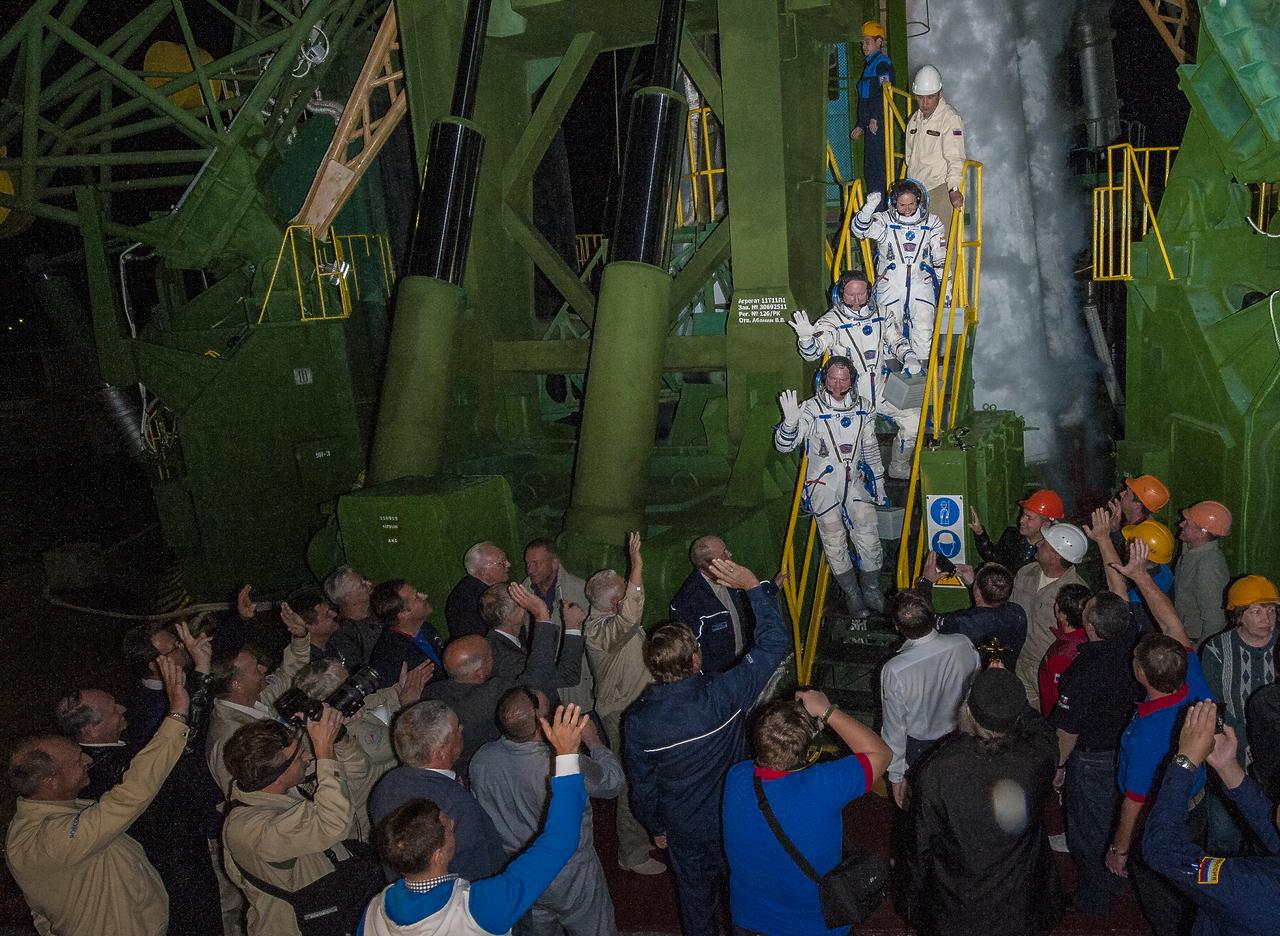Expedition 41 Soyuz Commander Alexander Samokutyaev of the Russian Federal Space Agency (Roscosmos), bottom, Flight Engineer Barry Wilmore of NASA, middle, and Flight Engineer Elena Serova of Roscosmos, top, wave farewell prior to boarding the Soyuz TMA-14M rocket for launch, Thursday, Sept. 25, 2014 at the Baikonur Cosmodrome in Kazakhstan. Samokutyaev, Serova, and Wilmore will spend the next five and a half months aboard the International Space Station. Serova will become the fourth Russian woman to fly in space and the first Russian woman to live and work on the station. Photo Credit: (NASA/Joel Kowsky)