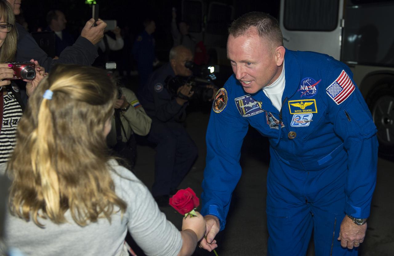 Expedition 41 Flight Engineer Barry Wilmore of NASA, gives a rose to his daughter, Daryn, before departing the Cosmonaut Hotel to suit-up for their Soyuz launch to the International Space Station on Thursday, Sept. 25, 2014, in Baikonur, Kazakhstan. Launch of the Soyuz rocket is scheduled for the early hours of Sept. 26 and will send Samokutyaev, Wilmore, and Serova on a five and a half month mission aboard the International Space Station. Photo Credit: (NASA/Aubrey Gemignani)