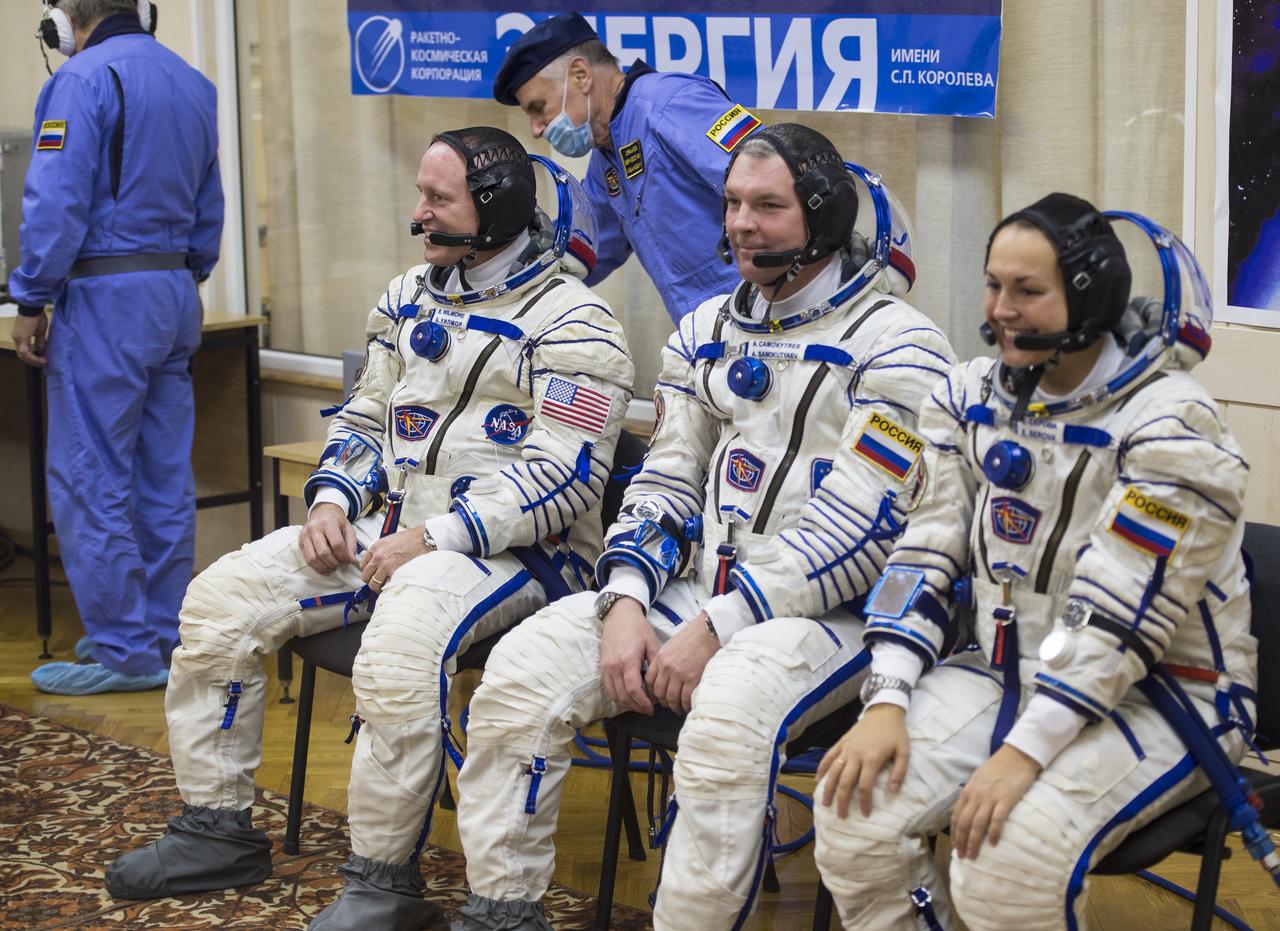 Expedition 41 Flight Engineer Barry Wilmore of NASA, left, Soyuz Commander Alexander Samokutyaev of the Russian Federal Space Agency (Roscosmos), and Flight Engineer Elena Serova of Roscosmos are seen while they wait to have their Russian Sokol suits pressure checked in preparation for their launch aboard the Soyuz TMA-14M spacecraft on Thursday, Sept. 25, 2014, at the Baiknour Cosmodrome, in Baikonur, Kazakhstan. Launch of the Soyuz rocket is scheduled for the early hours of Sept. 26 (Kazakhstan time) and will carry Wilmore, Samokutyaev, and Serova into orbit to begin their five and a half month mission on the International Space Station. Photo Credit: (NASA/Aubrey Gemignani)