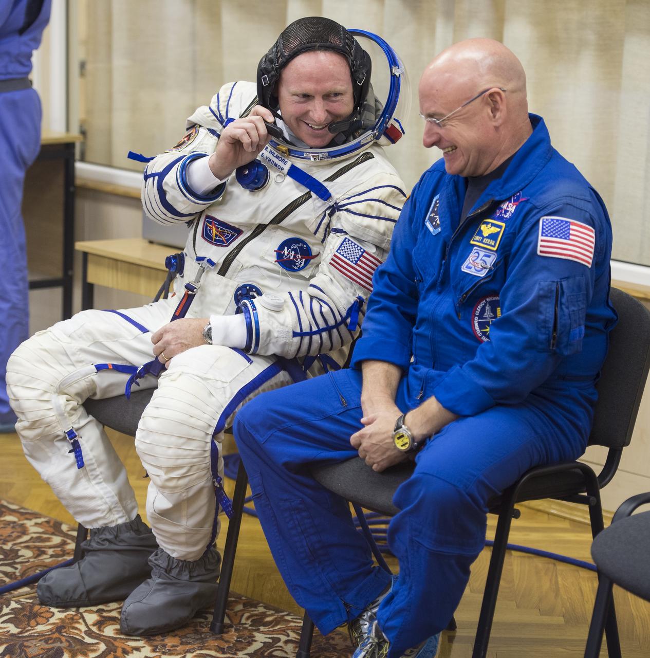 Expedition 41 Flight Engineer Barry Wilmore of NASA, left, speaks with backup crew member Flight Engineer Scott Kelly of NASA while he waits to have his Russian Sokol suit pressure checked in preparation for his launch aboard the Soyuz TMA-14M spacecraft on Thursday, Sept. 25, 2014, at the Baikonur Cosmodrome in Baikonur, Kazakhstan. Launch of the Soyuz rocket is scheduled for the early hours of Sept. 26 (Kazakhstan time) and will carry Wilmore and fellow crewmates, Flight Engineer Elena Serova and Soyuz Commander Alexander Samokutyaev of the Russian Federal Space Agency (Roscosmos), into orbit to begin their five and a half month mission on the International Space Station. Photo Credit: (NASA/Aubrey Gemignani)