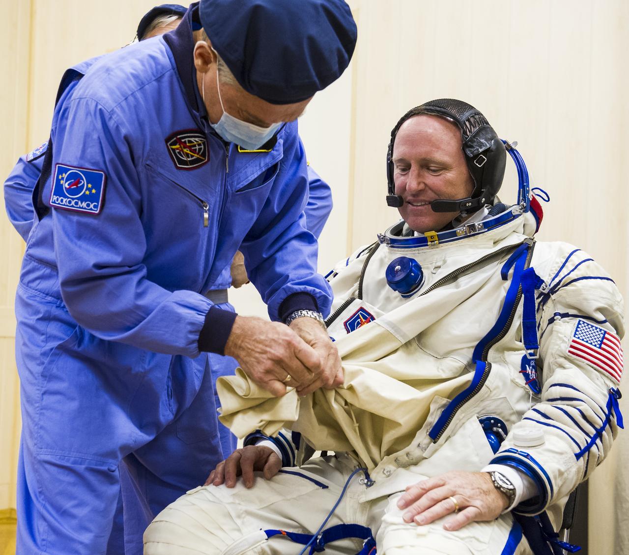Expedition 41 Flight Engineer Barry Wilmore of NASA is helped into his Russian Sokol suit as he and fellow crewmates, Flight Engineer Elena Serova and Soyuz Commander Alexander Samokutyaev of the Russian Federal Space Agency (Roscosmos), prepare for their Soyuz launch to the International Space Station, on Thursday, Sept. 25, 2014, at the Baikonur Cosmodrome in Baikonur, Kazakhstan. Launch of the Soyuz rocket is scheduled for the early hours of Sept. 26 and will carry Wilmore, Serova, and Samokutyaev into orbit to begin their five and a half month mission on the International Space Station. Photo Credit: (NASA/GCTC/Andrey Shelepin)
