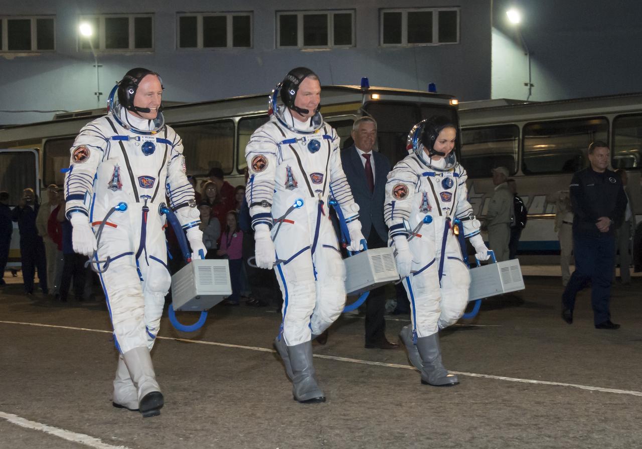 Expedition 41 Flight Engineer Barry Wilmore of NASA, left, Soyuz Commander Alexander Samokutyaev of the Russian Federal Space Agency (Roscosmos), center, and Flight Engineer Elena Serova of Roscosmos, right, are seen as they depart Building 254 following suitup on Thursday, Sept. 25, 2014 at the Baikonur Cosmodrome in Baikonur, Kazakhstan. The trio is set to launch on a five and a half month mission to the International Space Station onboard the Soyuz TMA-14M spacecraft at 2:25 a.m. Kazakhstan time on Friday, Sept. 26. Photo Credit: (NASA/Victor Zelentsov)
