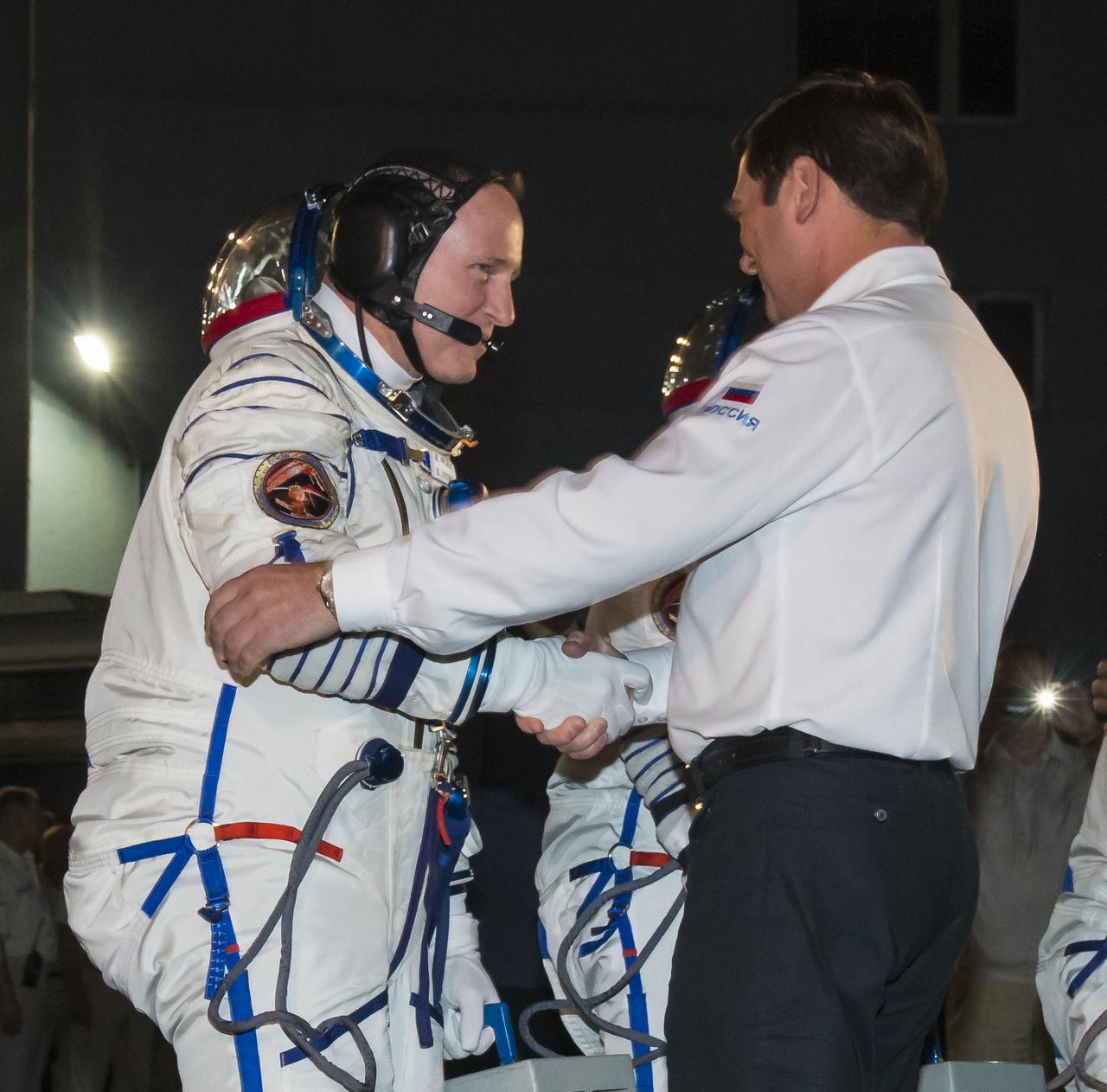 Oleg Ostapenko, General Director of the Russian Federal Space Agency (Roscosmos), right, shakes hands with Expedition 41 Flight Engineer Barry Wilmore of NASA, left, as he and crewmates Flight Engineer Elena Serova and Soyuz Commander Alexander Samokutyaev of the Russian Federal Space Agency (Roscosmos) prepare to depart for the launch pad on Thursday, Sept. 25, 2014, at the Baikonur Cosmodrome in Baikonur, Kazakhstan. Launch of the Soyuz rocket will send Wilmore, Serova, and Samokutyaev on a five and a half month mission aboard the International Space Station.  Photo Credit: (NASA/Victor Zelentsov)