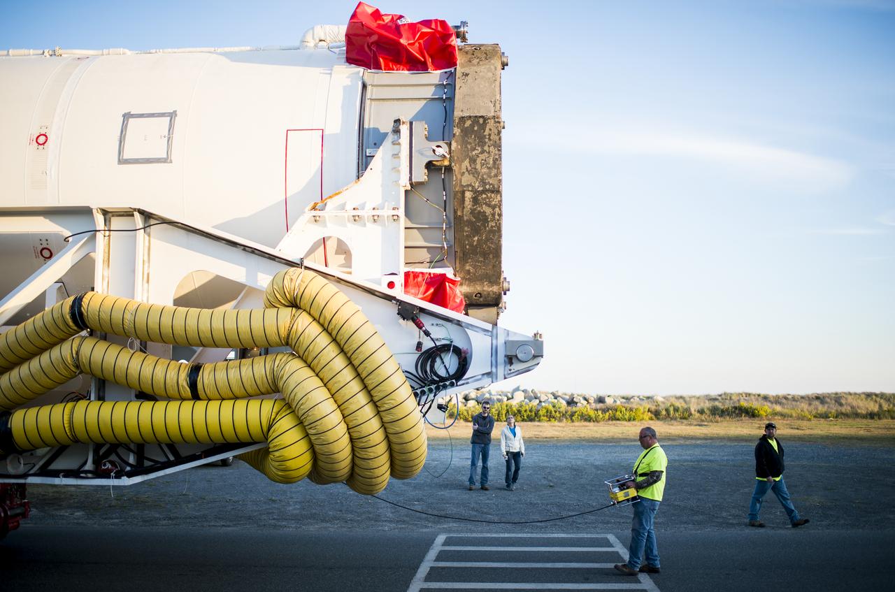 The Orbital Sciences Corporation Antares rocket, with the Cygnus spacecraft onboard, rolls from the Horizontal Integration Facility (HIF) to launch Pad-0A, Friday, Oct. 24, 2014, at NASA's Wallops Flight Facility in Virginia. The Antares will launch with the Cygnus spacecraft filled with over 5,000 pounds of supplies for the International Space Station, including science experiments, experiment hardware, spare parts, and crew provisions. The Orbital-3 mission is Orbital Sciences' third contracted cargo delivery flight to the space station for NASA. Photo Credit: (NASA/Joel Kowsky)