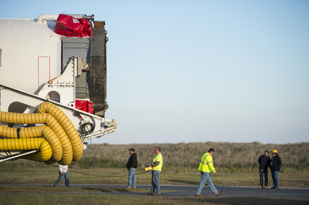 The Orbital Sciences Corporation Antares rocket, with the Cygnus spacecraft onboard, rolls from the Horizontal Integration Facility (HIF) to launch Pad-0A, Friday, Oct. 24, 2014, at NASA's Wallops Flight Facility in Virginia. The Antares will launch with the Cygnus spacecraft filled with over 5,000 pounds of supplies for the International Space Station, including science experiments, experiment hardware, spare parts, and crew provisions. The Orbital-3 mission is Orbital Sciences' third contracted cargo delivery flight to the space station for NASA. Photo Credit: (NASA/Joel Kowsky)
