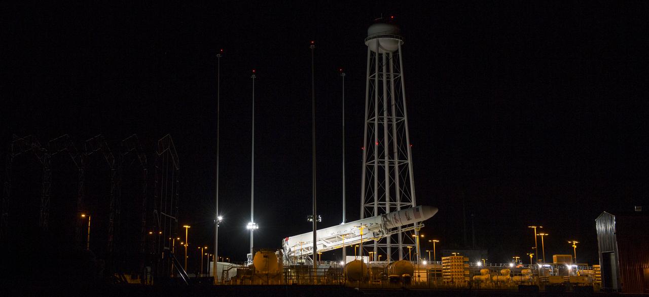 The Orbital Sciences Corporation Antares rocket, with the Cygnus spacecraft onboard, is raised at launch Pad-0A, Saturday, Oct. 25, 2014, at NASA's Wallops Flight Facility in Virginia. The Antares will launch with the Cygnus spacecraft filled with over 5,000 pounds of supplies for the International Space Station, including science experiments, experiment hardware, spare parts, and crew provisions. The Orbital-3 mission is Orbital Sciences' third contracted cargo delivery flight to the space station for NASA. Photo Credit: (NASA/Joel Kowsky)