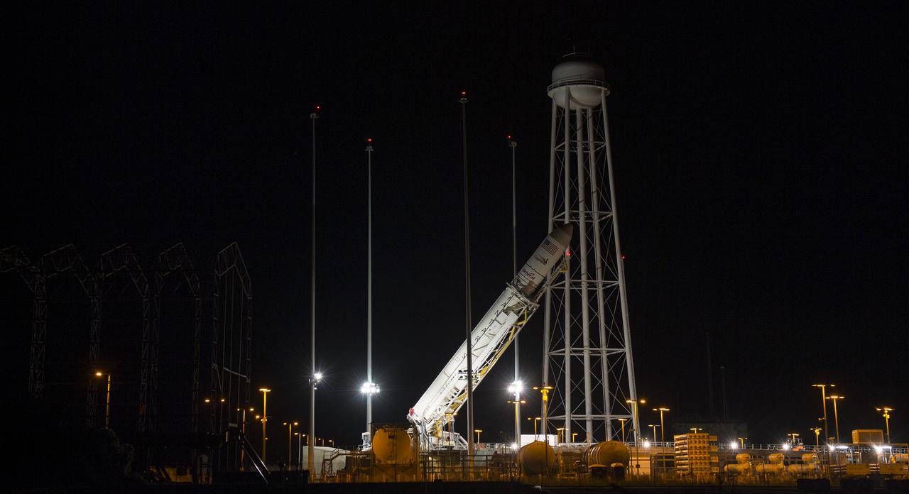 The Orbital Sciences Corporation Antares rocket, with the Cygnus spacecraft onboard, is raised at launch Pad-0A, Saturday, Oct. 25, 2014, at NASA's Wallops Flight Facility in Virginia. The Antares will launch with the Cygnus spacecraft filled with over 5,000 pounds of supplies for the International Space Station, including science experiments, experiment hardware, spare parts, and crew provisions. The Orbital-3 mission is Orbital Sciences' third contracted cargo delivery flight to the space station for NASA. Photo Credit: (NASA/Joel Kowsky)