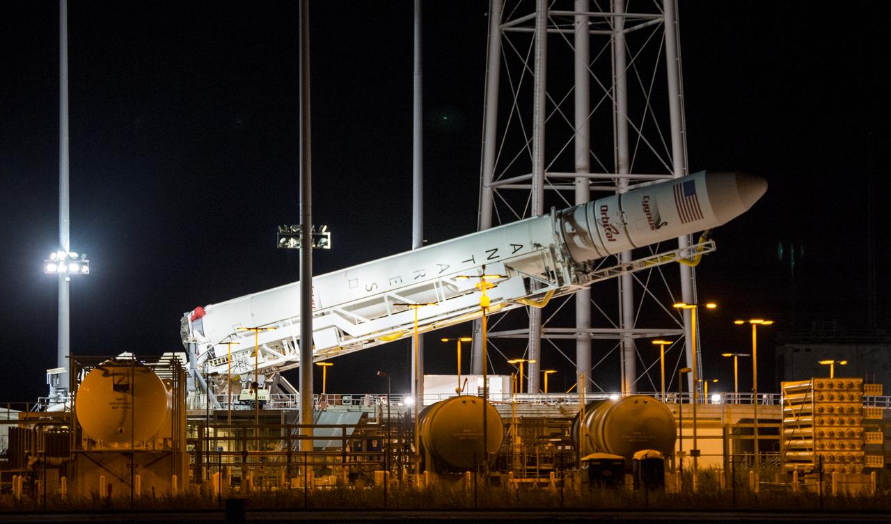 The Orbital Sciences Corporation Antares rocket, with the Cygnus spacecraft onboard, is raised at launch Pad-0A, Saturday, Oct. 25, 2014, at NASA's Wallops Flight Facility in Virginia. The Antares will launch with the Cygnus spacecraft filled with over 5,000 pounds of supplies for the International Space Station, including science experiments, experiment hardware, spare parts, and crew provisions. The Orbital-3 mission is Orbital Sciences' third contracted cargo delivery flight to the space station for NASA. Photo Credit: (NASA/Joel Kowsky)