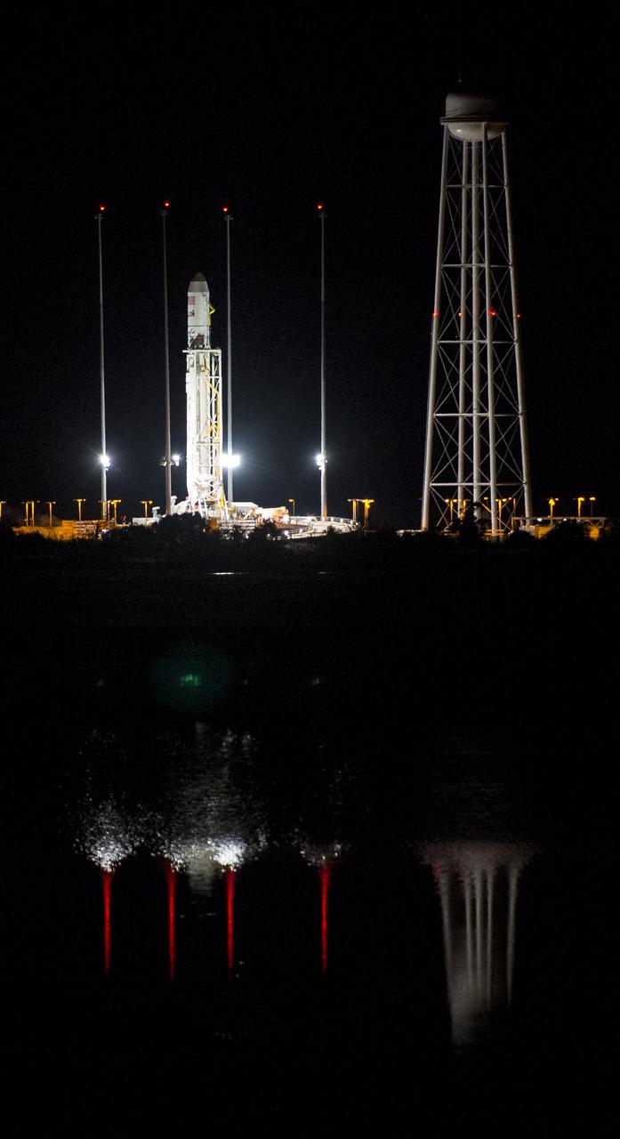 The Orbital Sciences Corporation Antares rocket, with the Cygnus spacecraft onboard, is seen after being raised into vertical position at launch Pad-0A, Saturday, Oct. 25, 2014, at NASA's Wallops Flight Facility in Virginia. The Antares will launch with the Cygnus spacecraft filled with over 5,000 pounds of supplies for the International Space Station, including science experiments, experiment hardware, spare parts, and crew provisions. The Orbital-3 mission is Orbital Sciences' third contracted cargo delivery flight to the space station for NASA. Photo Credit: (NASA/Joel Kowsky)