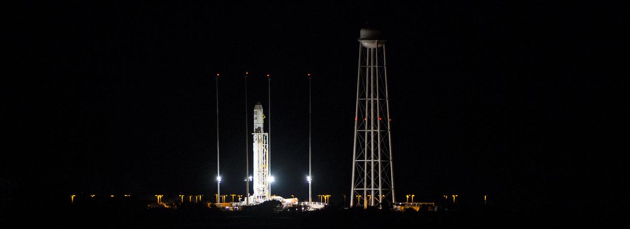 The Orbital Sciences Corporation Antares rocket, with the Cygnus spacecraft onboard, is seen after being raised into vertical position at launch Pad-0A, Saturday, Oct. 25, 2014, at NASA's Wallops Flight Facility in Virginia. The Antares will launch with the Cygnus spacecraft filled with over 5,000 pounds of supplies for the International Space Station, including science experiments, experiment hardware, spare parts, and crew provisions. The Orbital-3 mission is Orbital Sciences' third contracted cargo delivery flight to the space station for NASA. Photo Credit: (NASA/Joel Kowsky)