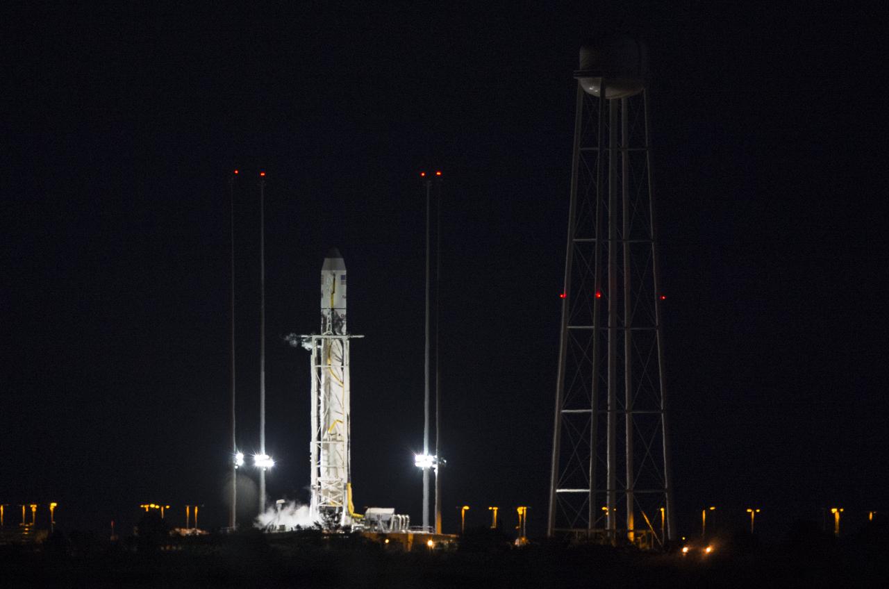 The Orbital Sciences Corporation Antares rocket, with the Cygnus spacecraft onboard, is seen on launch Pad-0A after the launch attempt was scrubbed because of a boat down range in the trajectory Antares would have flown had it lifted off, Monday, Oct. 27, 2014, at NASA's Wallops Flight Facility in Virginia. The Antares will launch with the Cygnus spacecraft filled with over 5,000 pounds of supplies for the International Space Station, including science experiments, experiment hardware, spare parts, and crew provisions. The Orbital-3 mission is Orbital Sciences' third contracted cargo delivery flight to the space station for NASA.  The next launch attempt will be made on Tuesday, Oct. 28 at 6:22 p.m. EDT.  Photo Credit: (NASA/Joel Kowsky)