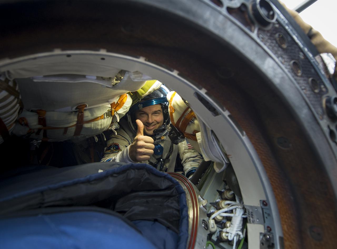 Expedition 41 Flight Engineer Reid Wiseman of NASA gives a thumbs up from inside the Soyuz Capsule just minutes after he and Expedition 41 Commander Max Suraev of the Russian Federal Space Agency (Roscosmos) and Flight Engineer Alexander Gerst of the European Space Agency (ESA) landed in their Soyuz TMA-13M capsule in a remote area near the town of Arkalyk, Kazakhstan on Monday, Nov. 10, 2014. Suraev, Wiseman and Gerst returned to Earth after more than five months onboard the International Space Station where they served as members of the Expedition 40 and 41 crews. Photo Credit: (NASA/Bill Ingalls)