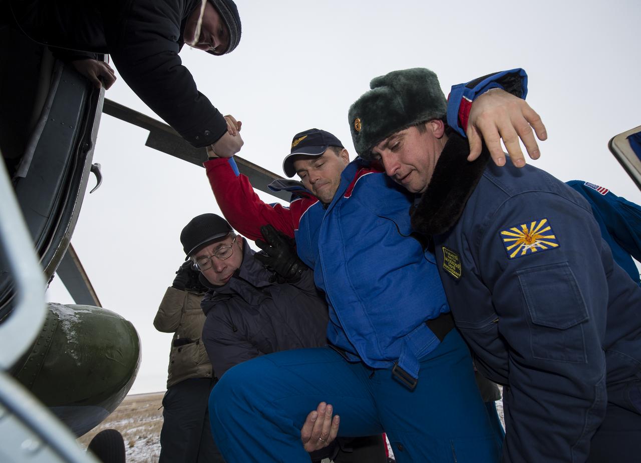 Expedition 41 Flight Engineer Reid Wiseman of NASA is helped from a Russian search and rescue all terrain vehicle (ATV) to his awaiting helicopter after he and Expedition 41 Commander Max Suraev of the Russian Federal Space Agency (Roscosmos) and Flight Engineer Alexander Gerst of the European Space Agency (ESA) landed in their Soyuz TMA-13M capsule in a remote area near the town of Arkalyk, Kazakhstan on Monday, Nov. 10, 2014. Suraev, Wiseman and Gerst returned to Earth after more than five months onboard the International Space Station where they served as members of the Expedition 40 and 41 crews. Photo Credit: (NASA/Bill Ingalls)