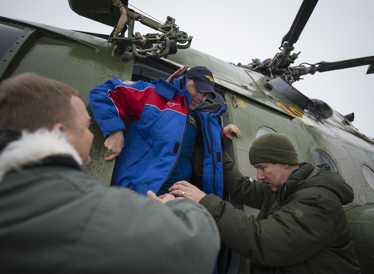 Expedition 41 Flight Engineer Reid Wiseman of NASA is helped out of a Russian search and rescue helicopter after being flown from his Soyuz TMA-13M spacecraft landing site near Arkalyk to Kustanay, Kazakhstan, Monday, Nov. 10, 2014. Wiseman landed in the soyuz capsule with Expedition 41 Commander Max Suraev of the Russian Federal Space Agency (Roscosmos) and Flight Engineer Alexander Gerst of the European Space Agency (ESA) a few hours earlier. Suraev, Wiseman and Gerst spent more than five months onboard the International Space Station where they served as members of the Expedition 40 and 41 crews. Photo Credit: (NASA/Bill Ingalls)