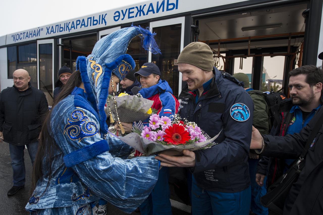 A woman in ceremonial Kazakh dress presents flowers to Expedition 41 Flight Engineer Alexander Gerst of the European Space Agency (ESA) at the Kustanay Airport after he and Expedition 41 Commander Max Suraev of the Russian Federal Space Agency (Roscosmos) and Flight Engineer Reid Wiseman of NASA landed in their Soyuz TMA-13M capsule in a remote area near the town of Arkalyk, Kazakhstan on Monday, Nov. 10, 2014. Suraev, Wiseman and Gerst returned to Earth after more than five months onboard the International Space Station where they served as members of the Expedition 40 and 41 crews. Photo Credit: (NASA/Bill Ingalls)