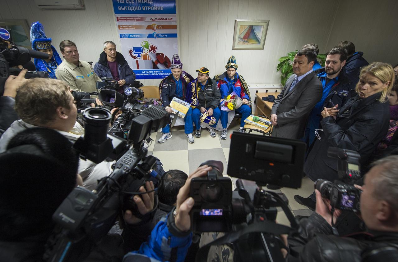Expedition 41 light Engineer Alexander Gerst of the European Space Agency (ESA), seated left, Commander Max Suraev of the Russian Federal Space Agency (Roscosmos), center, and NASA Flight Engineer Reid Wiseman, participate in a welcome ceremony and press conference at the Kustanay Airport shortly after arriving there via helicopter from their Soyuz landing site in a remote area near the town of Arkalyk, Kazakhstan on Monday, Nov. 10, 2014. Suraev, Wiseman and Gerst returned to Earth after more than five months onboard the International Space Station where they served as members of the Expedition 40 and 41 crews. Photo Credit: (NASA/Bill Ingalls)