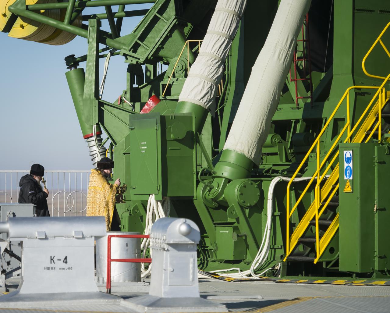 An Orthodox priest blesses the Soyuz rocket at the Baikonur Cosmodrome launch pad on Saturday Nov. 22, 2014, in Kazakhstan.  Launch of the Soyuz rocket is scheduled for Nov. 24 and will carry Expedition 42 Soyuz Commander Anton Shkaplerov of the Russian Federal Space Agency (Roscosmos), Flight Engineer Terry Virts of NASA , and Flight Engineer Samantha Cristoforetti of the European Space Agency into orbit to begin their five and a half month mission on the International Space Station. Photo Credit: (NASA/Aubrey Gemignani)