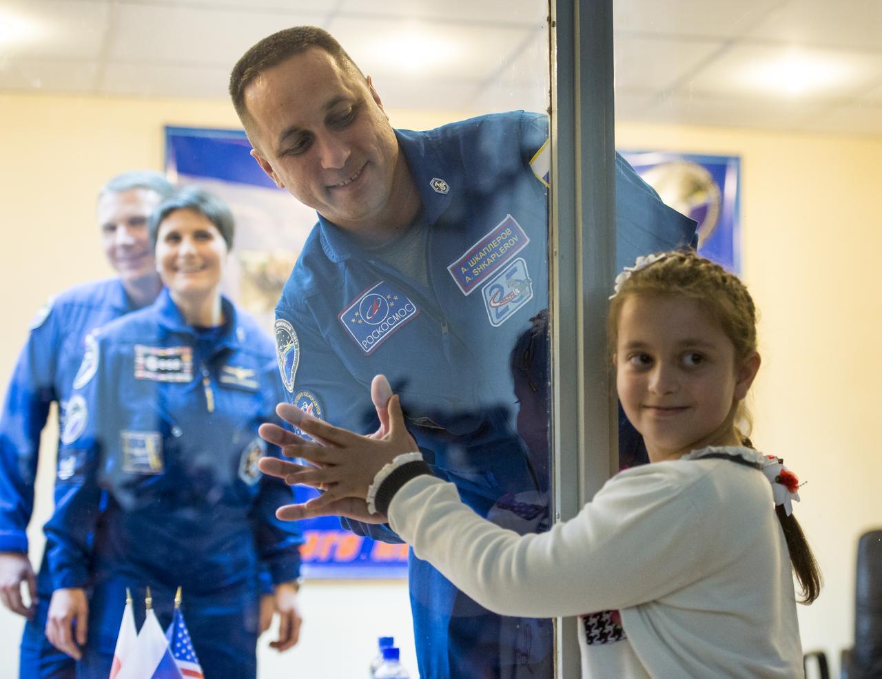 Family visits with Expedition 42 Soyuz Commander Anton Shkaplerov of the Russian Federal Space Agency (Roscosmos) through glass at the conclusion of the press conference, Saturday, Nov. 22, 2014, at the Cosmonaut Hotel in Baikonur, Kazakhstan. Launch of the Soyuz rocket is scheduled for Nov. 24 and will carry Shkaplerov, Flight Engineer Terry Virts of NASA , and Flight Engineer Samantha Cristoforetti of the European Space Agency into orbit to begin their five and a half month mission on the International Space Station. Photo Credit: (NASA/Aubrey Gemignani)