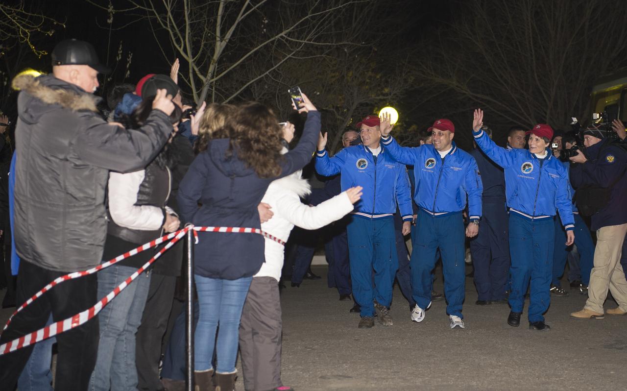 Expedition 42 crew members, Flight Engineer Terry Virts of NASA, left, Soyuz Commander Anton Shkaplerov of the Russian Federal Space Agency (Roscosmos), center,  and Flight Engineer Samantha Cristoforetti of the European Space Agency (ESA), right, wave farewell to family and friends as they depart the Cosmonaut Hotel to suit up for their Soyuz launch to the International Space Station on Sunday, Nov. 23, 2014, in Baikonur, Kazakhstan. Launch of the Soyuz rocket is scheduled for the early hours of Nov. 24 and will send Shkaplerov, Virts, and Cristoforetti on a five and a half month mission aboard the International Space Station. Photo Credit: (NASA/Aubrey Gemignani)