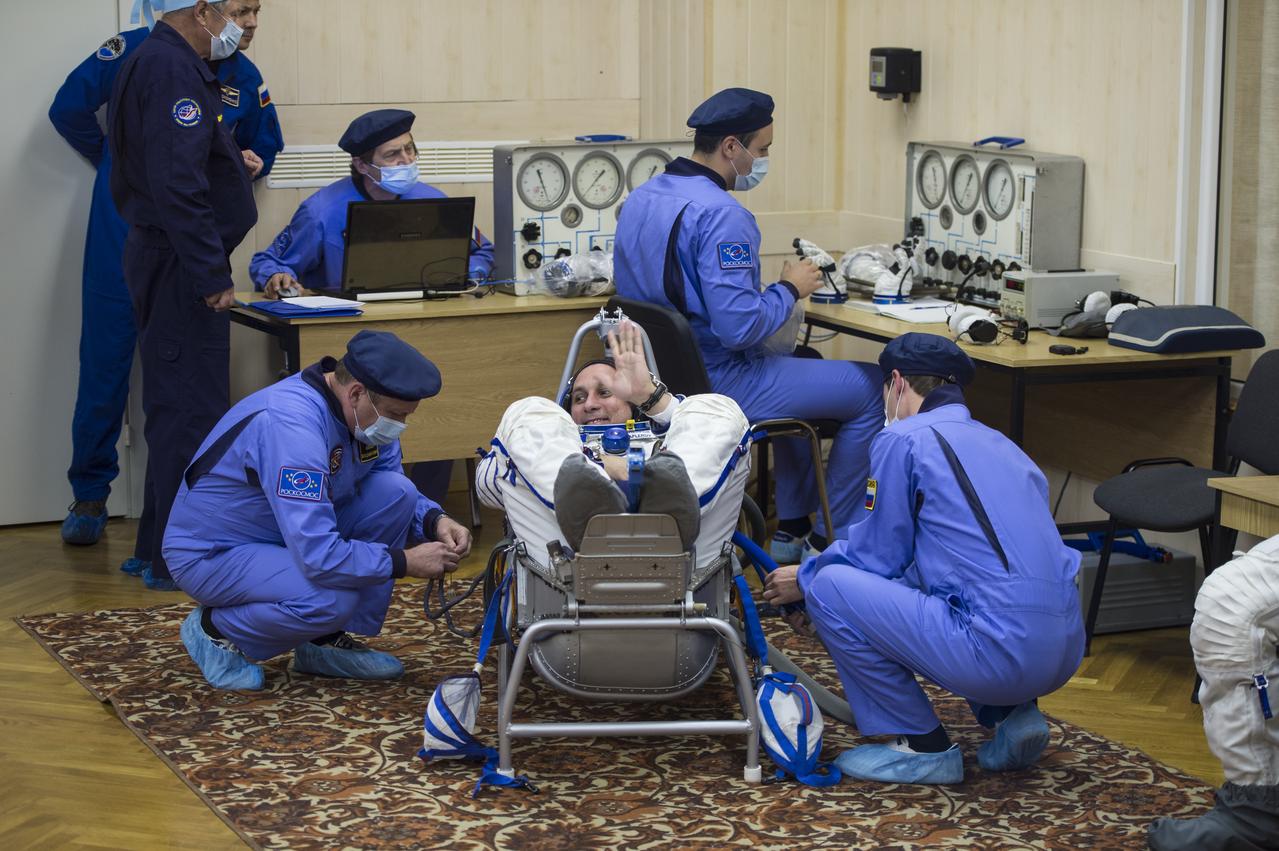 Expedition 42 Soyuz Commander Anton Shkaplerov of the Russian Federal Space Agency (Roscosmos) waves to friends and family as he has his Russian Sokol suit pressure checked in preparation for his launch aboard the Soyuz TMA-15M spacecraft on Sunday, Nov. 23, 2014, at Building 254 in the Baikonur Cosmodrome in Baikonur, Kazakhstan. Launch of the Soyuz rocket is scheduled for the early hours of Nov. 24 and will carry Shkaplerov and fellow crewmates, Flight Engineers Terry Virts of NASA and Samantha Cristoforetti of the European Space Agency (ESA) into orbit to begin their five and a half month mission on the International Space Station. Photo Credit: (NASA/Aubrey Gemignani)