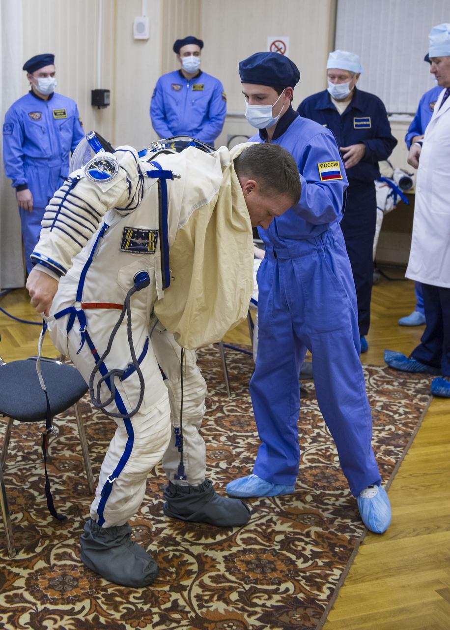 Expedition 42 Flight Engineer Terry Virts of NASA  is helped into his Russian Sokol suit as he and fellow crewmates, Flight Engineer Samantha Cristoforetti of the European Space Agency (ESA), and Soyuz Commander Anton Shkaplerov of the Russian Federal Space Agency (Roscosmos), prepare for their Soyuz launch to the International Space Station, on Sunday, Nov. 23, 2014, at the Baikonur Cosmodrome in Baikonur, Kazakhstan. Launch of the Soyuz rocket is scheduled for the early hours of Nov. 24 and will carry Virts, Cristoforetti, and Shkaplerov into orbit to begin their five and a half month mission on the International Space Station. Photo Credit: (NASA/GCTC/Andrey Shelepin)