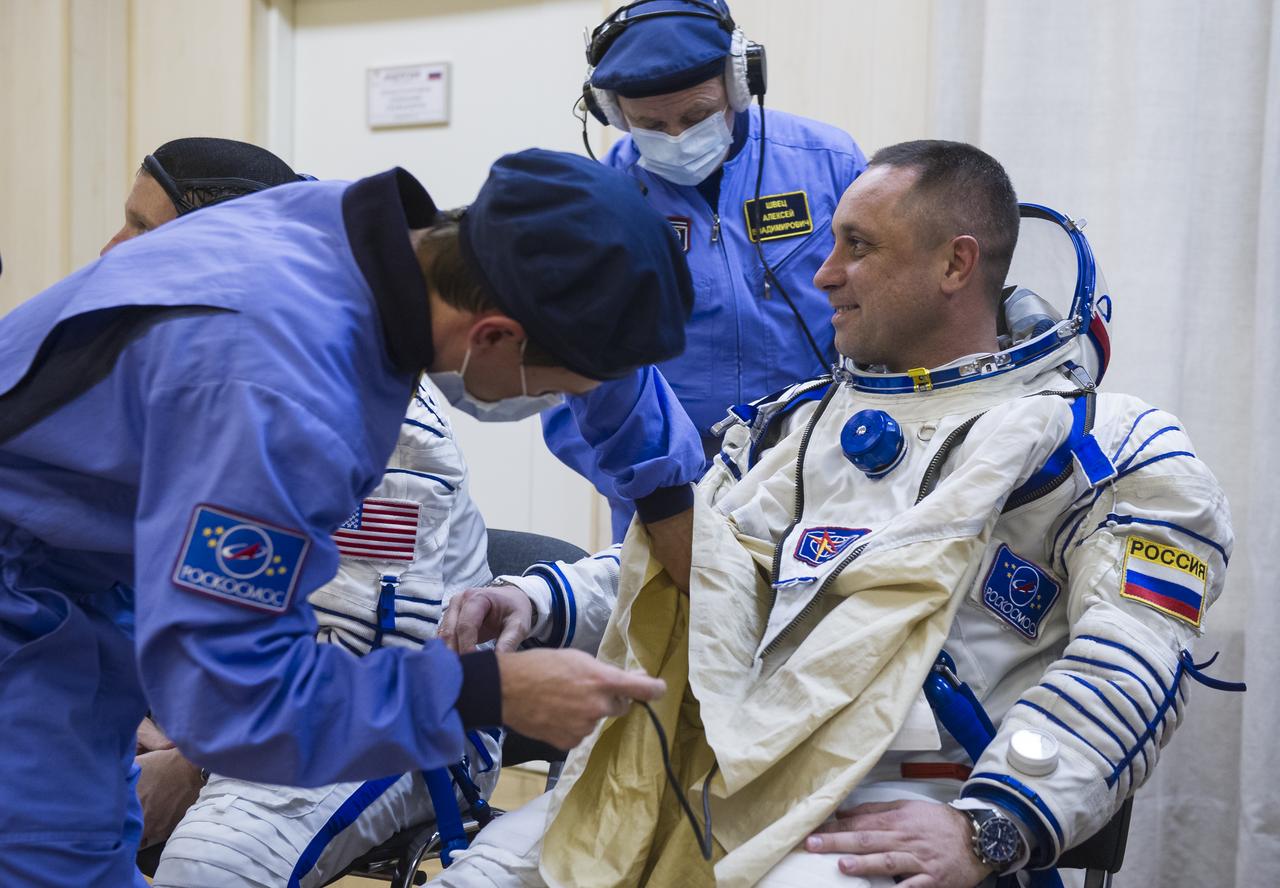 Expedition 42 Soyuz Commander Anton Shkaplerov of the Russian Federal Space Agency (Roscosmos) is helped into his Russian Sokol suit as he and fellow crewmates, Flight Engineer Samantha Cristoforetti of the European Space Agency (ESA), and Flight Engineer Terry Virts of NASA  prepare for their Soyuz launch to the International Space Station, on Sunday, Nov. 23, 2014, at the Baikonur Cosmodrome in Baikonur, Kazakhstan. Launch of the Soyuz rocket is scheduled for the early hours of Nov. 24 and will carry Shkaplerov, Virts, and Cristoforetti into orbit to begin their five and a half month mission on the International Space Station. Photo Credit: (NASA/GCTC/Andrey Shelepin)