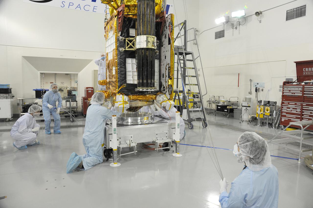 VANDENBERG AIR FORCE BASE, Calif. – Technicians prepare to lift NASA's Soil Moisture Active Passive, or SMAP, spacecraft in preparation to move it toward the Delta II payload attach structure in the Astrotech payload processing facility on Vandenberg Air Force Base in California. The structure will secure the spacecraft to the rocket's second stage.  SMAP will launch on a Delta II 7320 configuration vehicle featuring a United Launch Alliance first stage booster powered by an Aerojet Rocketdyne RS-27A main engine and three Alliant Techsystems, or ATK, strap-on solid rocket motors. Once on station in Earth orbit, SMAP will provide global measurements of soil moisture and its freeze_thaw state. These measurements will be used to enhance understanding of processes that link the water, energy and carbon cycles, and to extend the capabilities of weather and climate prediction models. SMAP data also will be used to quantify net carbon flux in boreal landscapes and to develop improved flood prediction and drought monitoring capabilities. Launch from Space Launch Complex 2 is targeted for Jan. 29, 2015. To learn more about SMAP, visit http:__www.nasa.gov_smap.  Photo credit: NASA_Chris Wiant, U.S. Air Force Photo Squadron