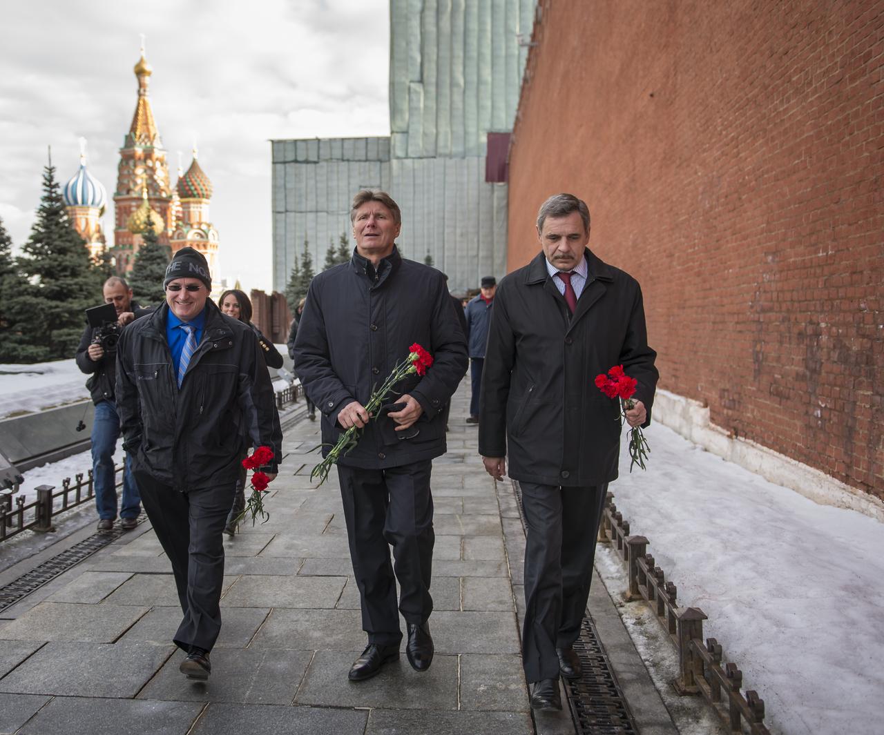 Expedition 43 NASA Astronaut Scott Kelly, left, Russian cosmonaut Gennady Padalka of the Russian Federal Space Agency (Roscosmos), center, and Russian cosmonaut Mikhail Kornienko of Roscosmos walk along the Kremlin Wall in Red Square to leave roses at the site where Russian space icons are interred as part of traditional pre-launch ceremonies, Friday, March 6, 2015, Moscow, Russia. The trio is preparing for launch to the International Space Station in their Soyuz TMA-16M spacecraft from the Baikonur Cosmodrome in Kazakhstan March 28, Kazakh time. As the one-year crew, Kelly and Kornienko will return to Earth on Soyuz TMA-18M in March 2016. Photo Credit: (NASA/Bill Ingalls)