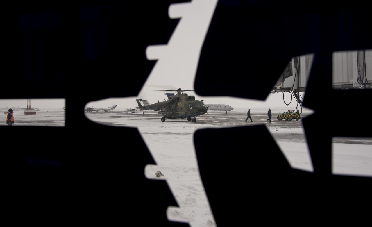 A Russian MI-8 Helicopter is seen through the airport bus decal a day before the Soyuz TMA-14M spacecraft landing with Expedition 42 commander Barry Wilmore of NASA, Alexander Samokutyaev of the Russian Federal Space Agency (Roscosmos) and Elena Serova of Roscosmos Wednesday, March 11, 2015 in Karaganda, Kazakhstan. NASA Astronaut Wilmore, Russian Cosmonauts Samokutyaev and Serova are returning after almost six months onboard the International Space Station where they served as members of the Expedition 41 and 42 crews. Photo Credit: (NASA/Bill Ingalls)