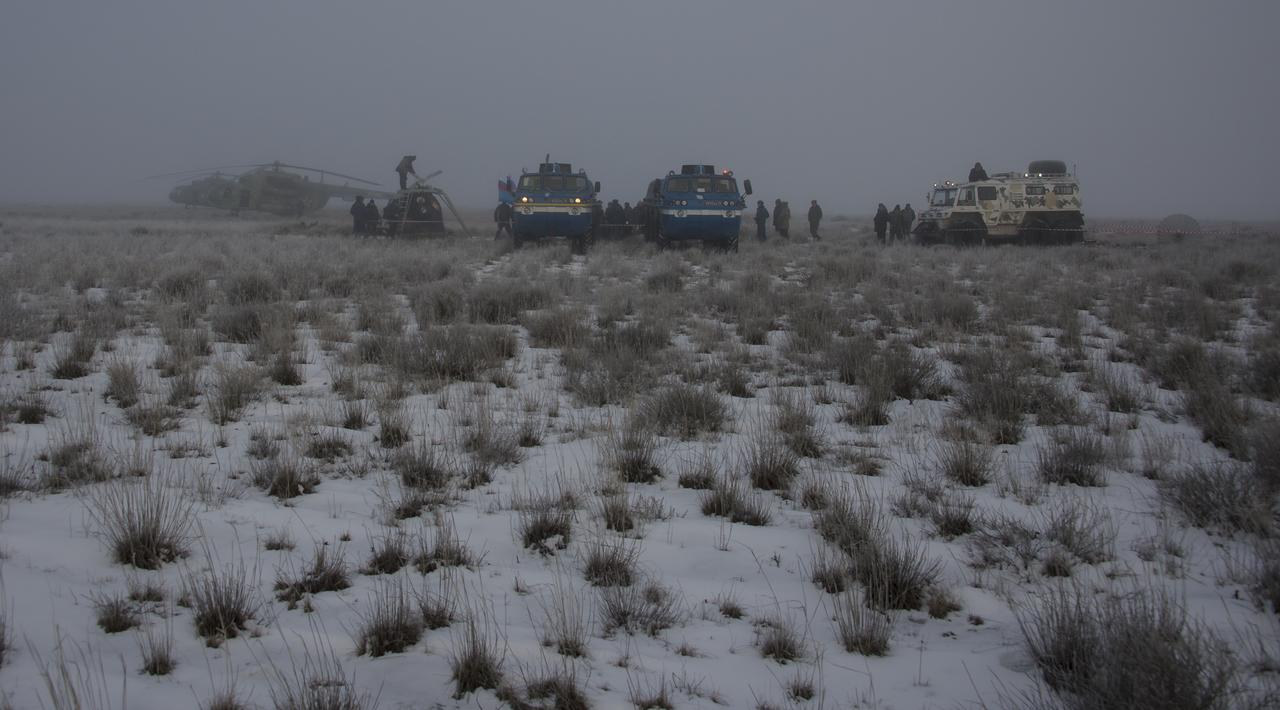 The Soyuz TMA-14M spacecraft, support helicopters, and all terrain vehicles are seen at the landing site where Expedition 42 commander Barry Wilmore of NASA, Alexander Samokutyaev of the Russian Federal Space Agency (Roscosmos) and Elena Serova of Roscosmos landed near the town of Zhezkazgan, Kazakhstan on Thursday, March 12, 2015. NASA Astronaut Wilmore, Russian Cosmonauts Samokutyaev and Serova are returning after almost six months onboard the International Space Station where they served as members of the Expedition 41 and 42 crews. Photo Credit: (NASA/Bill Ingalls)