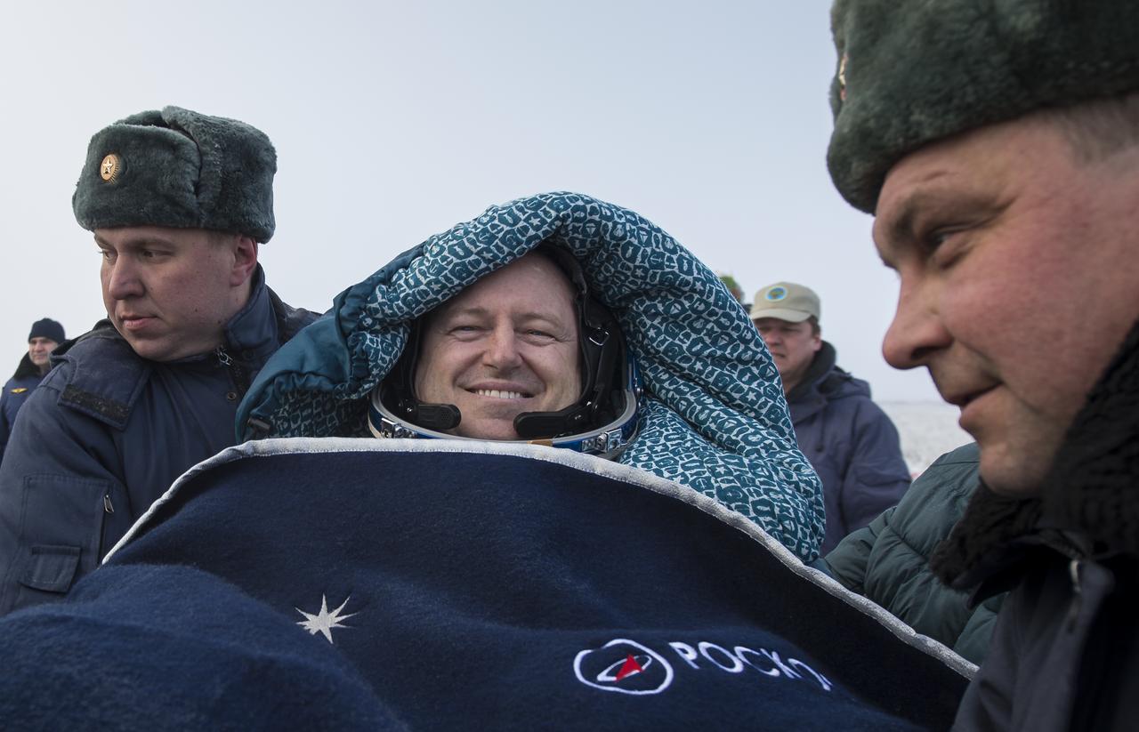 Expedition 42 commander Barry Wilmore of NASA is carried in a chair to an all terrain vehicle (ATV) shortly after he and Alexander Samokutyaev of the Russian Federal Space Agency (Roscosmos), and Elena Serova of Roscosmos landed in their Soyuz TMA-14M spacecraft in a remote area near the town of Zhezkazgan, Kazakhstan on Thursday, March 12, 2015. NASA Astronaut Wilmore, Russian Cosmonauts Samokutyaev and Serova are returning after almost six months onboard the International Space Station where they served as members of the Expedition 41 and 42 crews. Photo Credit: (NASA/Bill Ingalls)