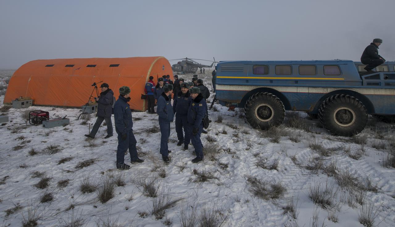 Russian support personnel wait outside the medical tent and all terrain vehicles (ATVs) after the Soyuz TMA-14M spacecraft landed with Expedition 42 commander Barry Wilmore of NASA, Alexander Samokutyaev of the Russian Federal Space Agency (Roscosmos) and Elena Serova of Roscosmos near the town of Zhezkazgan, Kazakhstan on Thursday, March 12, 2015. NASA Astronaut Wilmore, Russian Cosmonauts Samokutyaev and Serova are returning after almost six months onboard the International Space Station where they served as members of the Expedition 41 and 42 crews. Photo Credit: (NASA/Bill Ingalls)