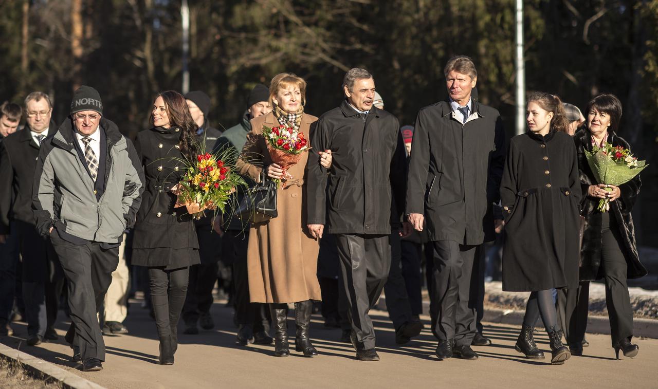 Expedition 43 NASA Astronaut Scott Kelly, left, and Russian Cosmonauts Mikhail Kornienko, center, and Gennady Padalka of the Russian Federal Space Agency (Roscosmos) walk with family and friends as they depart the Gagarin Cosmonaut Training Center (GCTC) in Star City, Russia, for Baikonur, Kazakhstan, Saturday, March 14, 2015. The trio are preparing for launch to the International Space Station in their Soyuz TMA-16M spacecraft from the Baikonur Cosmodrome in Kazakhstan March 28, Kazakh time. As the one-year crew, Kelly and Kornienko will return to Earth on Soyuz TMA-18M in March 2016. Photo Credit: (NASA/Bill Ingalls)
