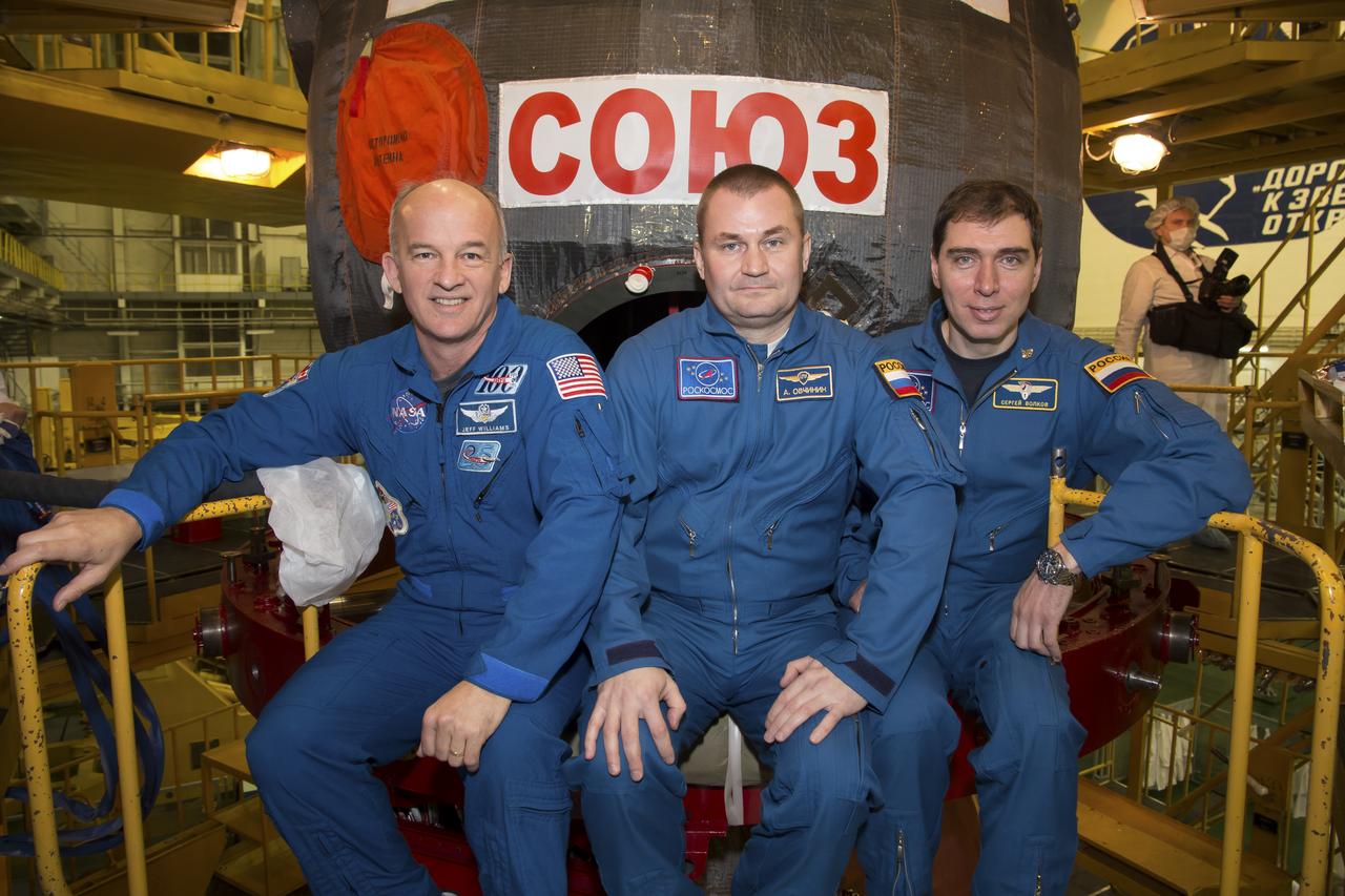 Expedition 43 backup crew members Jeff Williams of NASA, left, Alexey Ovchinin, center, and Sergei Volkov of Russia's Federal Space Agency (Roscosmos) take a moment during the Soyuz TMA-16M spacecraft fit check to pose for a photograph, Sunday, March 15, 2015 at the Baikonur Cosmodrome in Kazakhstan. The prime crew members Russian Cosmonauts Mikhail Kornienko, Gennady Padalka of the Russian Federal Space Agency (Roscosmos), and NASA Astronaut Scott Kelly are preparing for launch to the International Space Station in their Soyuz TMA-16M spacecraft from the Baikonur Cosmodrome in Kazakhstan March 28, Kazakh time. As the one-year crew, Kelly and Kornienko will return to Earth on Soyuz TMA-18M in March 2016. Photo Credit: (NASA/Victor Zelentsov)