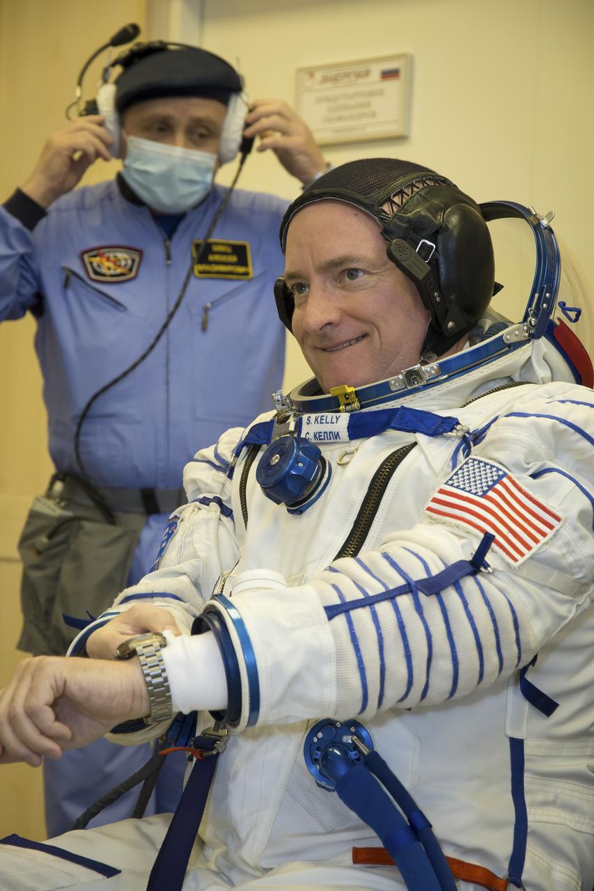 Expedition 43 NASA Astronaut Scott Kelly dons his Russian sokol suit during the Soyuz TMA-16M spacecraft fit check with Russian Cosmonauts Gennady Padalka and, Mikhail Kornienko of the Russian Federal Space Agency (Roscosmos), Sunday, March 15, 2015 at the Baikonur Cosmodrome in Kazakhstan. The trio are preparing for launch to the International Space Station in their Soyuz TMA-16M spacecraft from the Baikonur Cosmodrome in Kazakhstan March 28, Kazakh time. As the one-year crew, Kelly and Kornienko will return to Earth on Soyuz TMA-18M in March 2016. Photo Credit: (NASA/Victor Zelentsov)