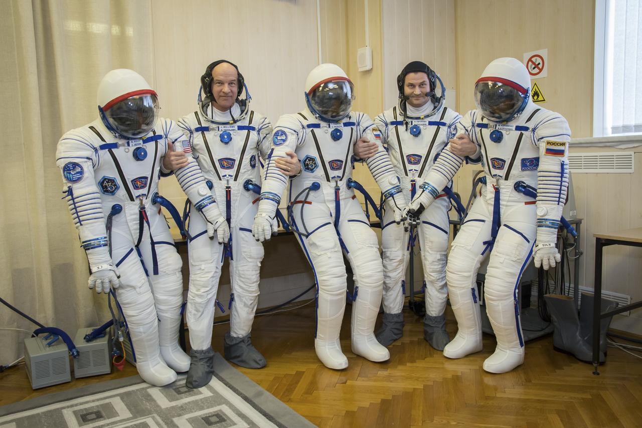 Expedition 43 backup crew members Jeff Williams of NASA, left, and Alexey Ovchinin of Russia's Federal Space Agency (Roscosmos) take a moment during their Soyuz TMA-16M spacecraft fit check to pose for a photograph while holding their pressurized Russian Sokol suits, including the suit of their fellow backup crew member Sergei Volkov, Sunday, March 15, 2015 at the Baikonur Cosmodrome in Kazakhstan. The prime crew members Russian Cosmonauts Mikhail Kornienko, Gennady Padalka of the Russian Federal Space Agency (Roscosmos), and NASA Astronaut Scott Kelly are preparing for launch to the International Space Station in their Soyuz TMA-16M spacecraft from the Baikonur Cosmodrome in Kazakhstan March 28, Kazakh time. As the one-year crew, Kelly and Kornienko will return to Earth on Soyuz TMA-18M in March 2016. Photo Credit: (NASA/Victor Zelentsov)