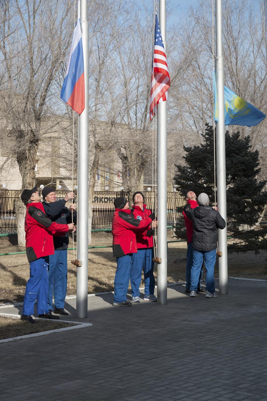 Expedition 43 prime and backup crew members: Russian Cosmonauts Mikhail Kornienko, left, Gennady Padalka, of the Russian Federal Space Agency (Roscosmos), NASA Astronauts Scott Kelly, and Jeff Williams, andRussian Cosmonauts, Alexei Ovchinin, and Sergei Volkov of Roscosmos participate in the traditional flag raising ceremony at the Cosmonaut Hotel, Monday, March 16, 2015 in Baikonur, Kazakhstan. Kelly, Padalka, and Kornienko are preparing for launch to the International Space Station in their Soyuz TMA-16M spacecraft from the Baikonur Cosmodrome in Kazakhstan March 28, Kazakh time. As the one-year crew, Kelly and Kornienko will return to Earth on Soyuz TMA-18M in March 2016. Photo Credit: (NASA/Victor Zelentsov)