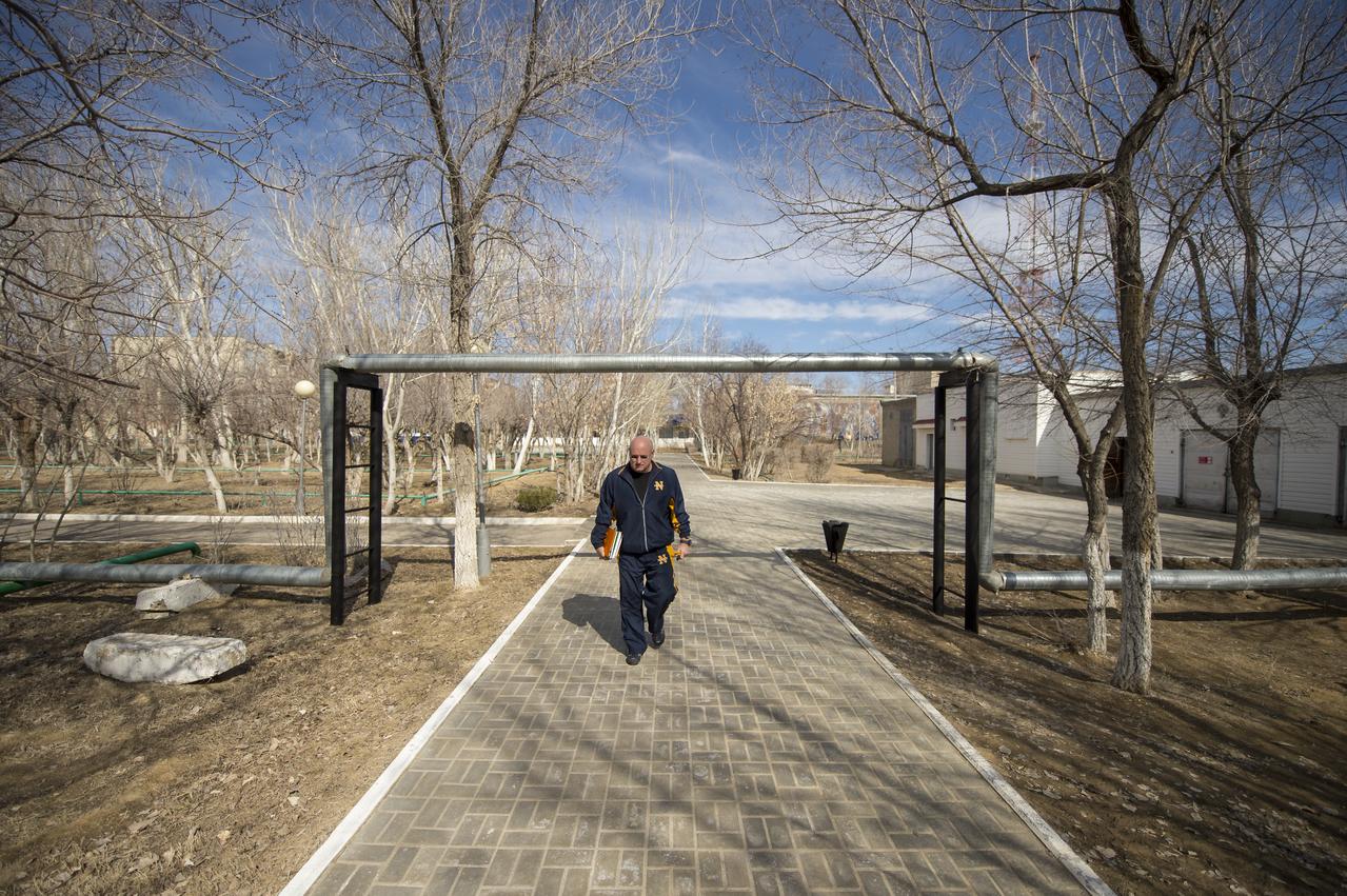 Expedition 43 NASA Astronaut Scott Kelly walks from morning classes at the Cosmonaut Hotel to his crew quarters at the Zvjozdnyj Hotel, Thursday, March 19, 2015 in Baikonur, Kazakhstan. Kelly, and Russian Cosmonauts Gennady Padalka, and Mikhail Kornienko of the Russian Federal Space Agency (Roscosmos) are preparing for launch to the International Space Station in their Soyuz TMA-16M spacecraft from the Baikonur Cosmodrome in Kazakhstan March 28, Kazakh time. As the one-year crew, Kelly and Kornienko will return to Earth on Soyuz TMA-18M in March 2016. Photo Credit: (NASA/Bill Ingalls)