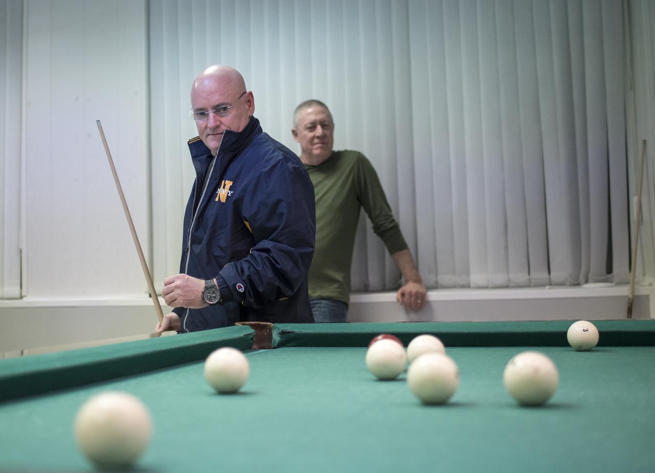 Expedition 43 NASA Astronaut Scott Kelly, left, plays pool with Russian Cosmonaut Mikhail Kornienko of the Russian Federal Space Agency (Roscosmos), as NASA International Space Station Program Manager for International and Crew Operations Michael Baker looks on at the Cosmonaut Hotel, Thursday, March 19, 2015 in Baikonur, Kazakhstan. Kelly, Kornienko, and Russian Cosmonaut Gennady Padalka are preparing for launch to the International Space Station in their Soyuz TMA-16M spacecraft from the Baikonur Cosmodrome in Kazakhstan March 28, Kazakh time. As the one-year crew, Kelly and Kornienko will return to Earth on Soyuz TMA-18M in March 2016. Photo Credit: (NASA/Bill Ingalls)