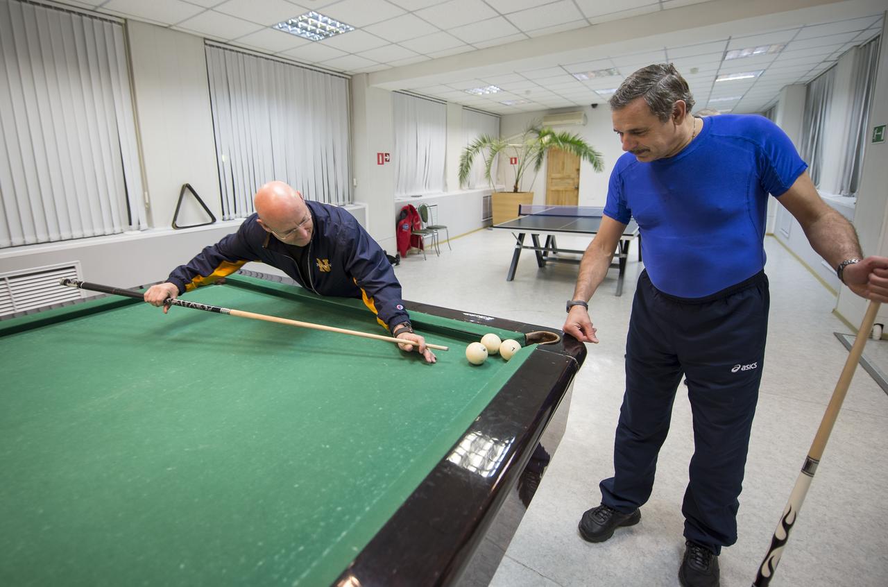 Expedition 43 NASA Astronaut Scott Kelly, left, plays pool with Russian Cosmonaut Mikhail Kornienko of the Russian Federal Space Agency (Roscosmos) at the Cosmonaut Hotel, Thursday, March 19, 2015 in Baikonur, Kazakhstan. Kelly, Kornienko, and Russian Cosmonaut Gennady Padalka are preparing for launch to the International Space Station in their Soyuz TMA-16M spacecraft from the Baikonur Cosmodrome in Kazakhstan March 28, Kazakh time. As the one-year crew, Kelly and Kornienko will return to Earth on Soyuz TMA-18M in March 2016. Photo Credit: (NASA/Bill Ingalls)
