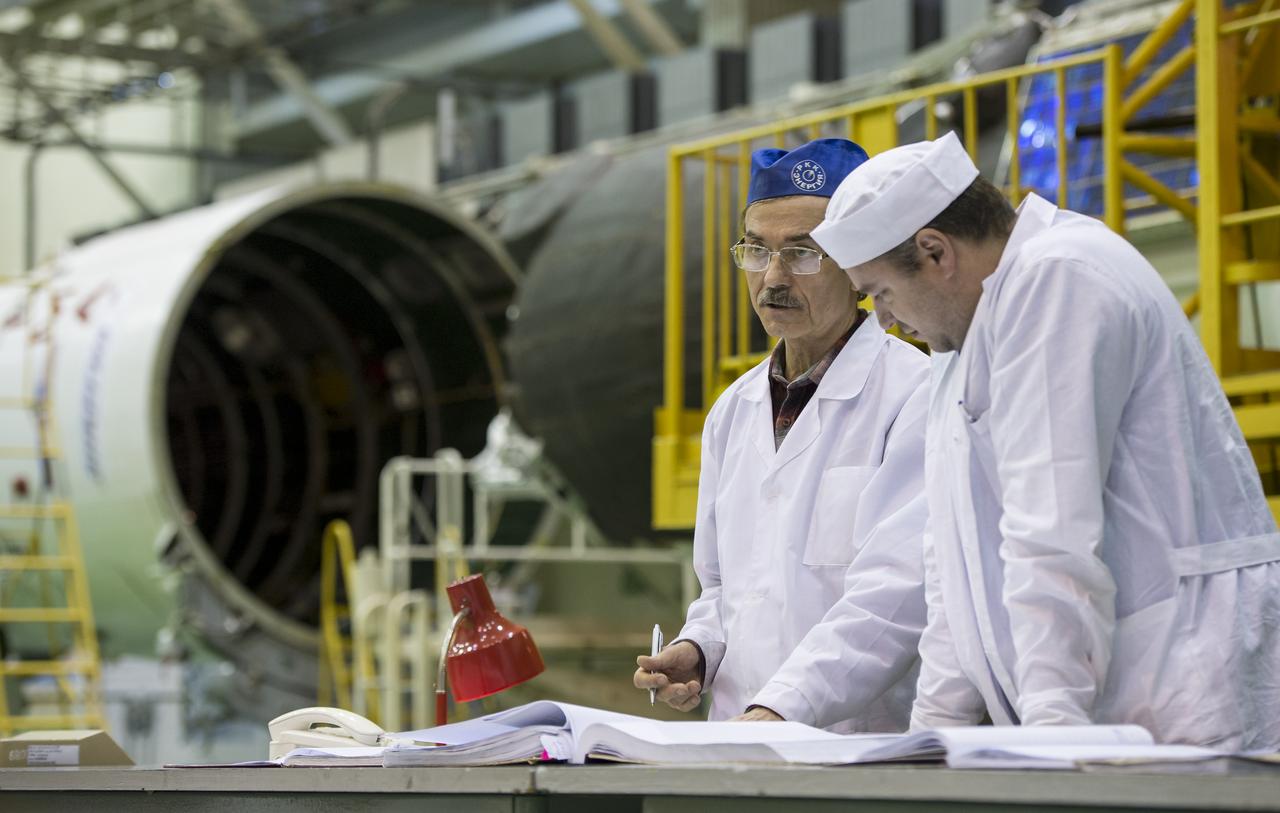 Workers review documents after the Soyuz TMA-16M spacecraft is lowered into position for encapsulation with its fairing, Friday, March 20, 2015 at the Baikonur Cosmodrome in Kazakhstan. Expedition 43 NASA Astronaut Scott Kelly, and Russian Cosmonauts Gennady Padalka, and Mikhail Kornienko of the Russian Federal Space Agency (Roscosmos) are scheduled to launch to the International Space Station in the Soyuz TMA-16M spacecraft from the Baikonur Cosmodrome in Kazakhstan March 28, Kazakh time. As the one-year crew, Kelly and Kornienko will return to Earth on Soyuz TMA-18M in March 2016. Photo Credit: (NASA/Bill Ingalls)