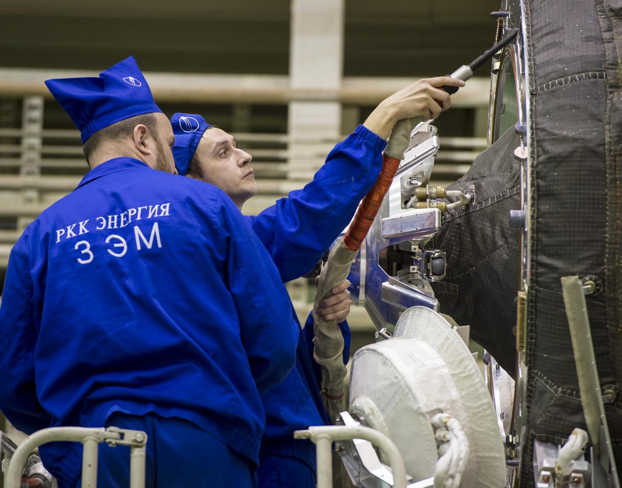 Workers clean the Soyuz TMA-16M spacecraft after it is lowered into position for encapsulation with its fairing, Friday, March 20, 2015 at the Baikonur Cosmodrome in Kazakhstan. Expedition 43 NASA Astronaut Scott Kelly, and Russian Cosmonauts Gennady Padalka, and Mikhail Kornienko of the Russian Federal Space Agency (Roscosmos) are scheduled to launch to the International Space Station in the Soyuz TMA-16M spacecraft from the Baikonur Cosmodrome in Kazakhstan March 28, Kazakh time. As the one-year crew, Kelly and Kornienko will return to Earth on Soyuz TMA-18M in March 2016. Photo Credit: (NASA/Bill Ingalls)