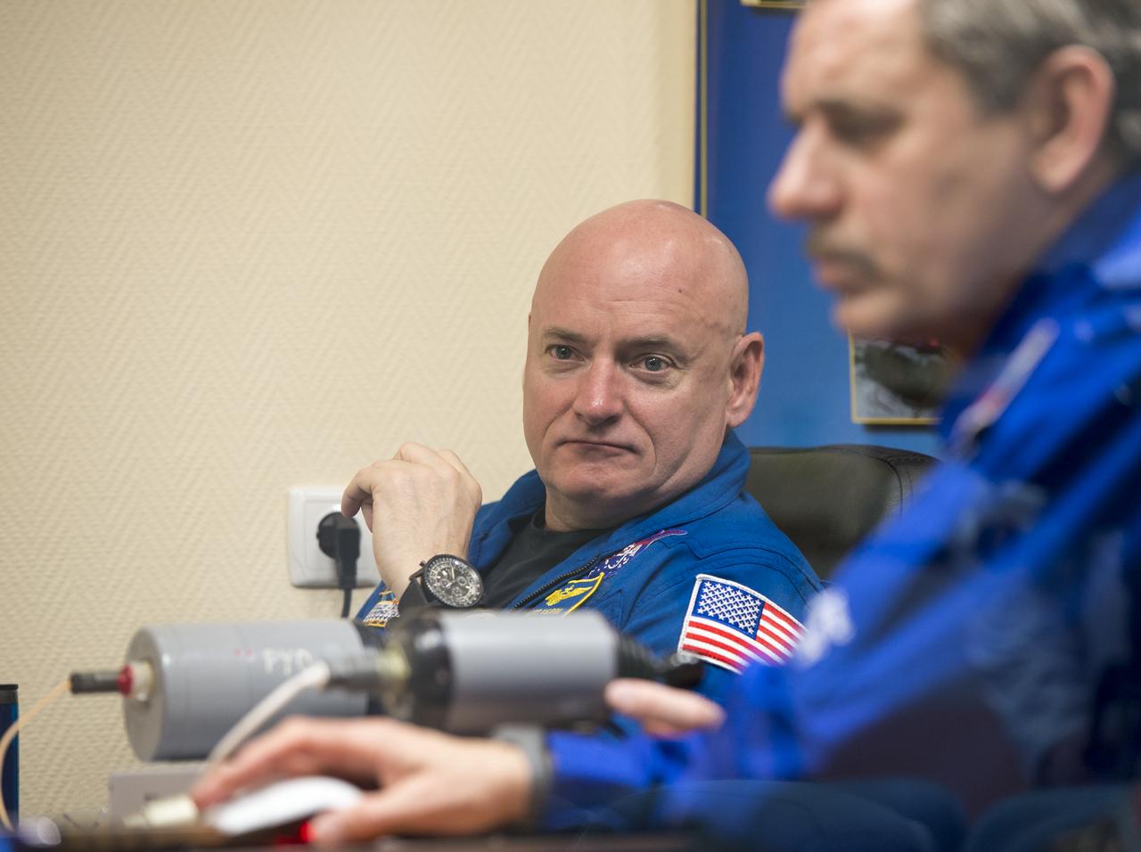 Expedition 43 NASA Astronaut Scott Kelly, watches carefully as Russian Cosmonauts Gennady Padalka, and Mikhail Kornienko of the Russian Federal Space Agency (Roscosmos) work on Soyuz training, Saturday, March 21, 2015 at the Cosmonaut Hotel in Baikonur, Kazakhstan. Kelly, Padalka, and Kornienko are preparing for launch to the International Space Station in their Soyuz TMA-16M spacecraft from the Baikonur Cosmodrome in Kazakhstan March 28, Kazakh time (March 27 Eastern time.) As the one-year crew, Kelly and Kornienko will return to Earth on Soyuz TMA-18M in March 2016. Photo Credit: (NASA/Bill Ingalls)