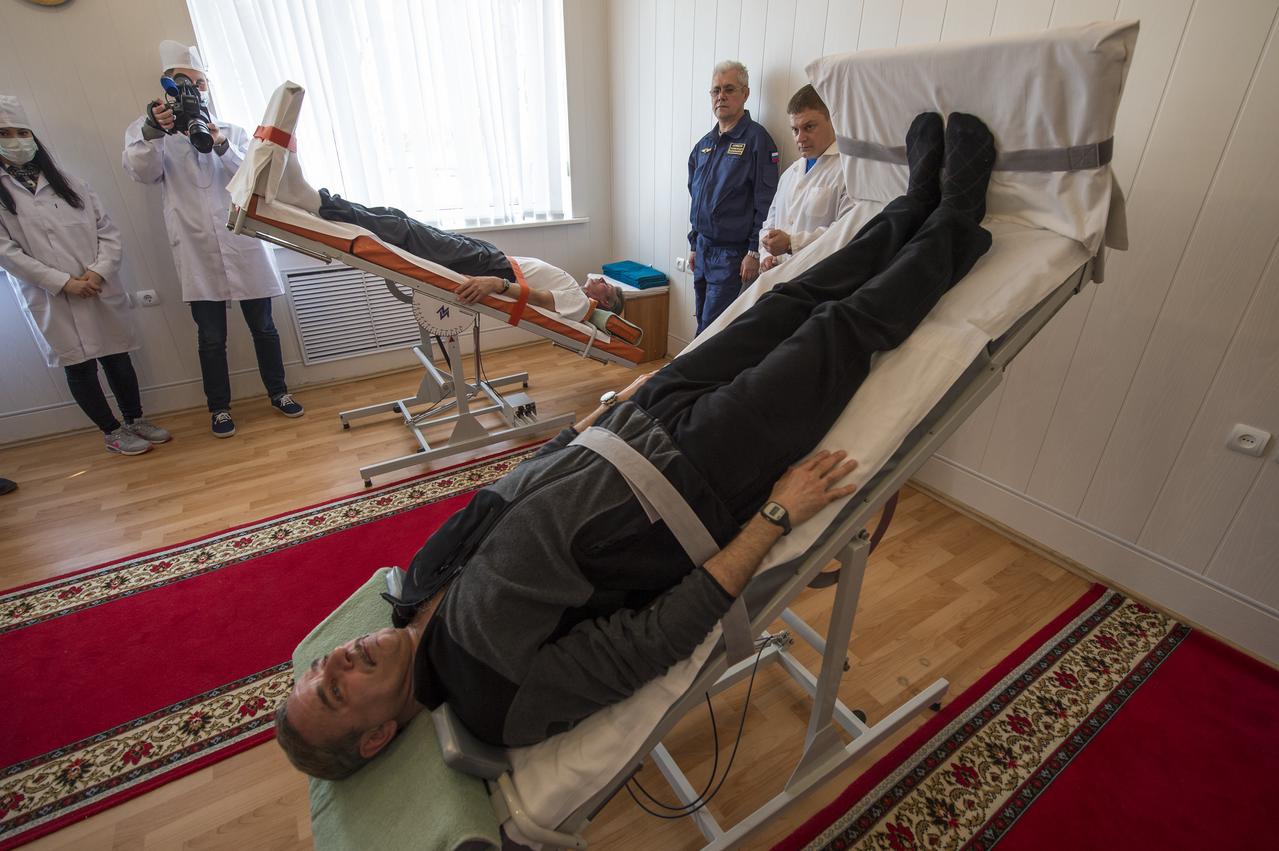 Expedition 43 Russian Cosmonauts Gennady Padalka, background, and Mikhail Kornienko of the Russian Federal Space Agency (Roscosmos) take part the tilt table training during media day, Saturday, March 21, 2015, Baikonur, Kazakhstan. Padalka, Kornienko, and Expedition 43 NASA Astronaut Scott Kelly are scheduled to launch to the International Space Station in the Soyuz TMA-16M spacecraft from the Baikonur Cosmodrome in Kazakhstan March 28, Kazakh time (March 27 Eastern time.) As the one-year crew, Kelly and Kornienko will return to Earth on Soyuz TMA-18M in March 2016. Photo Credit: (NASA/Bill Ingalls)