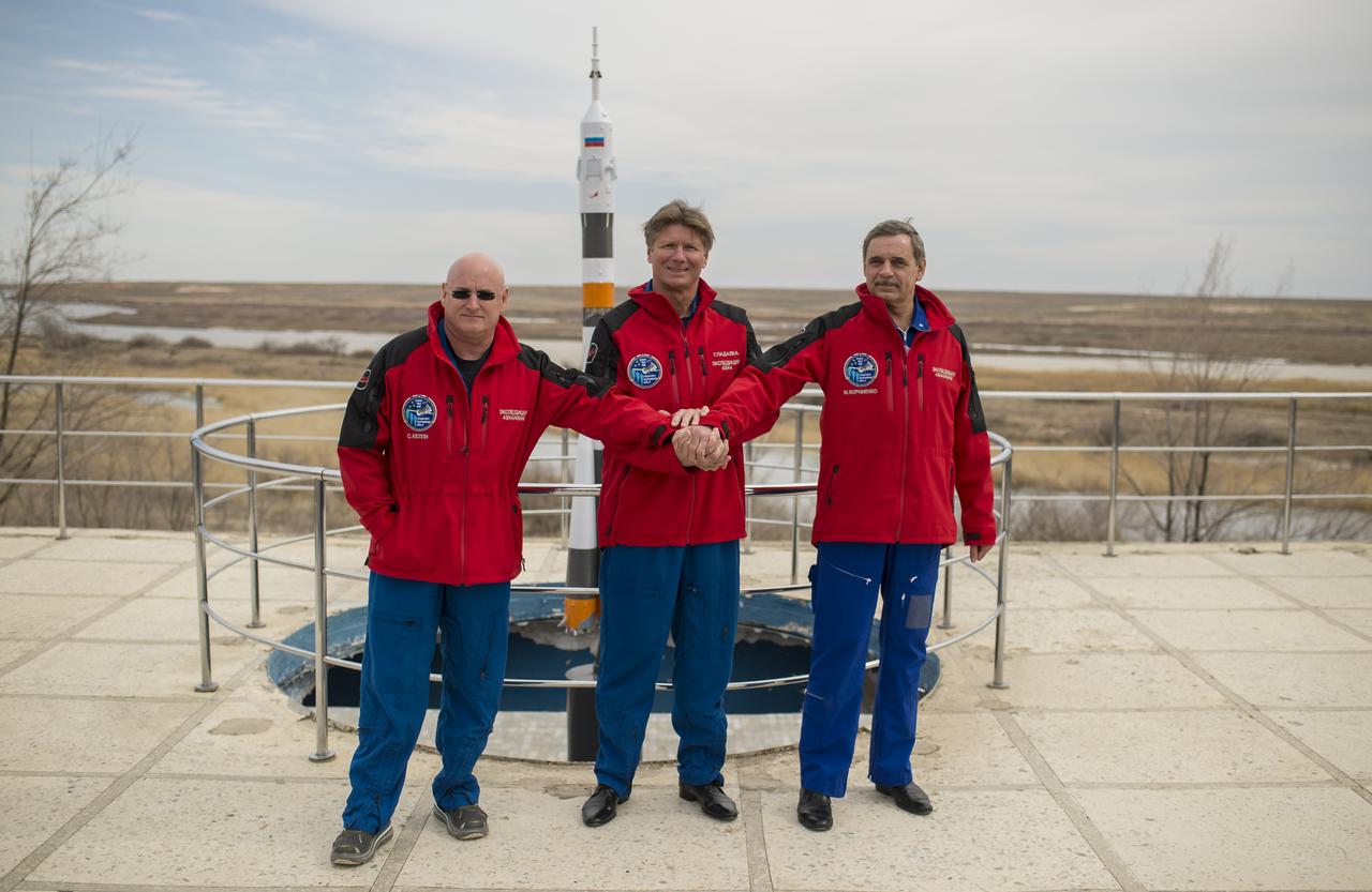 Expedition 43 NASA Astronaut Scott Kelly, left, Russian Cosmonauts Gennady Padalka, center, and Mikhail Kornienko of the Russian Federal Space Agency (Roscosmos) pose for a group photo near a model of the Soyuz rocket during media day, Saturday, March 21, 2015 at the Cosmonaut Hotel in Baikonur, Kazakhstan. Kelly, Padalka, and Kornienko are preparing for launch to the International Space Station in their Soyuz TMA-16M spacecraft from the Baikonur Cosmodrome in Kazakhstan March 28, Kazakh time (March 27 Eastern time.) As the one-year crew, Kelly and Kornienko will return to Earth on Soyuz TMA-18M in March 2016. Photo Credit: (NASA/Bill Ingalls)