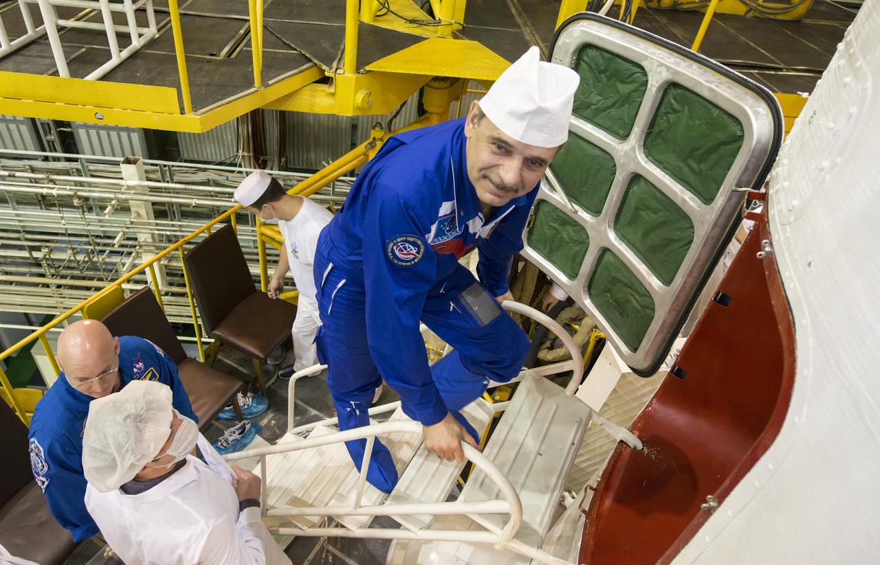 Expedition 43 Russian Cosmonaut Mikhail Kornienko of the Russian Federal Space Agency (Roscosmos) climbs the stairs to enter the Soyuz TMA-16M spacecraft during the final check of the spacecraft with NASA Astronaut Scott Kelly, seated left, and Russian Cosmonaut Gennady Padalka, Monday, March 23, 2015 at the Baikonur Cosmodrome in Kazakhstan. Kelly, Kornienko, and Padalka are scheduled to launch to the International Space Station in the Soyuz TMA-16M spacecraft from the Baikonur Cosmodrome in Kazakhstan March 28, Kazakh time (March 27 Eastern time.) As the one-year crew, Kelly and Kornienko will return to Earth on Soyuz TMA-18M in March 2016. Photo Credit: (NASA/Bill Ingalls)