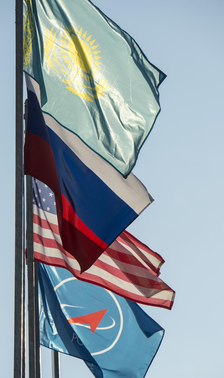 The flags of Kazakhstan, Russia, The United States, and the Russian Federal Space Agency (Roscosmos) are seen flying at teh launch pad after the Soyuz TMA-16M spacecraft was rolled out by train at the Baikonur Cosmodrome, Kazakhstan, Wednesday, March 25, 2015. NASA Astronaut Scott Kelly, and Russian Cosmonauts Mikhail Kornienko, and Gennady Padalka of the Russian Federal Space Agency (Roscosmos) are scheduled to launch to the International Space Station in the Soyuz TMA-16M spacecraft from the Baikonur Cosmodrome in Kazakhstan March 28, Kazakh time (March 27 Eastern time.) As the one-year crew, Kelly and Kornienko will return to Earth on Soyuz TMA-18M in March 2016.  Photo Credit (NASA/Bill Ingalls)