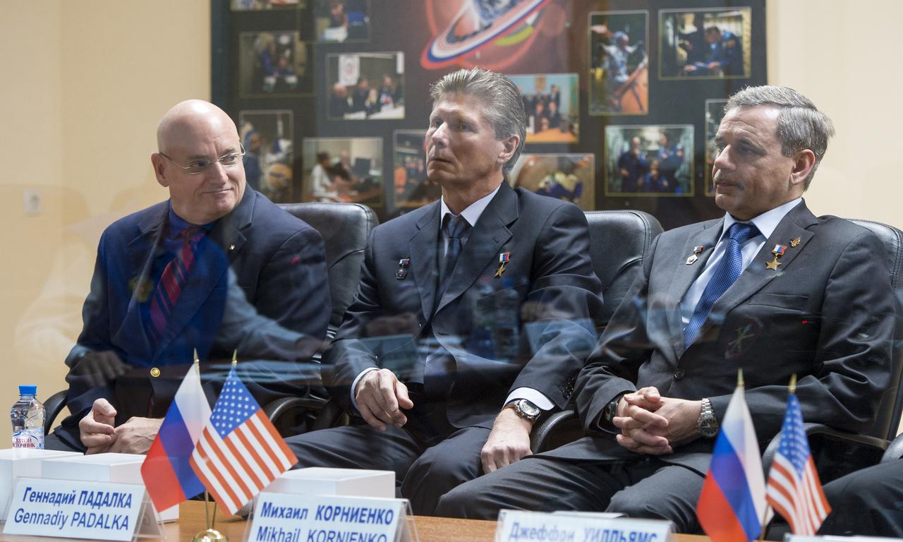 Expedition 43 NASA Astronaut Scott Kelly, left, Russian cosmonauts Gennady Padalka, center, and Mikhail Kornienko of the Russian Federal Space Agency (Roscosmos), are sen in quarentine behind glass during the State Commission meeting to approve the Soyuz launch to the International Space Station, Thursday, March 26, 2015, at the Cosmonaut Hotel in Baikonur, Kazakhstan. Kelly, Kornienko, and Padalka launched to the International Space Station in the Soyuz TMA-16M spacecraft from the Baikonur Cosmodrome in Kazakhstan March 28, Kazakh time (March 27 Eastern time.) As the one-year crew, Kelly and Kornienko will return to Earth on Soyuz TMA-18M in March 2016.  Photo Credit (NASA/Bill Ingalls)