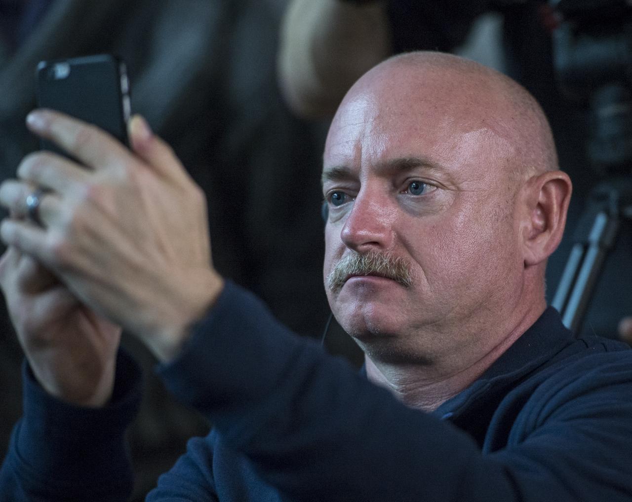 Retired NASA Astronaut Mark Kelly photographs his identical twin brother, NASA Astronaut Scott Kelly, as Scott Kelly and fellow crew mates, Russian cosmonauts Gennady Padalka, and Mikhail Kornienko of the Russian Federal Space Agency (Roscosmos) participate in a press conference, Thursday, March 26, 2015, at the Cosmonaut Hotel in Baikonur, Kazakhstan. Mark Kelly, who flew four space shuttle missions and commanded the final flight of space shuttle Endeavour, will participate in biomedical studies on the ground while his twin is on board the orbiting laboratory. Scott Kelly, Kornienko, and Padalka launched to the International Space Station in the Soyuz TMA-16M spacecraft from the Baikonur Cosmodrome in Kazakhstan March 28, Kazakh time (March 27 Eastern time.) As the one-year crew, Kelly and Kornienko will return to Earth on Soyuz TMA-18M in March 2016.  Photo Credit (NASA/Bill Ingalls)