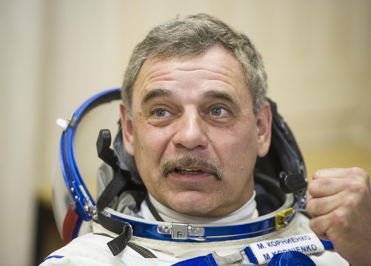 Expedition 43 Russian Cosmonaut Mikhail Kornienko of the Russian Federal Space Agency (Roscosmos) dons his Russian sokol suit ahead of his launch onboard the Soyuz TMA-16M spacecraft to the International Space Station with fellow crew mates, NASA Astronaut Scott Kelly, and Russian Cosmonaut Gennady Padalka of Roscosmos Friday, March 27, 2015 in Baikonor, Kazakhstan. As the one-year crew, Kelly and Kornienko will return to Earth on Soyuz TMA-18M in March 2016.  Photo Credit: (NASA/GCTC/Andrey Shelepin)